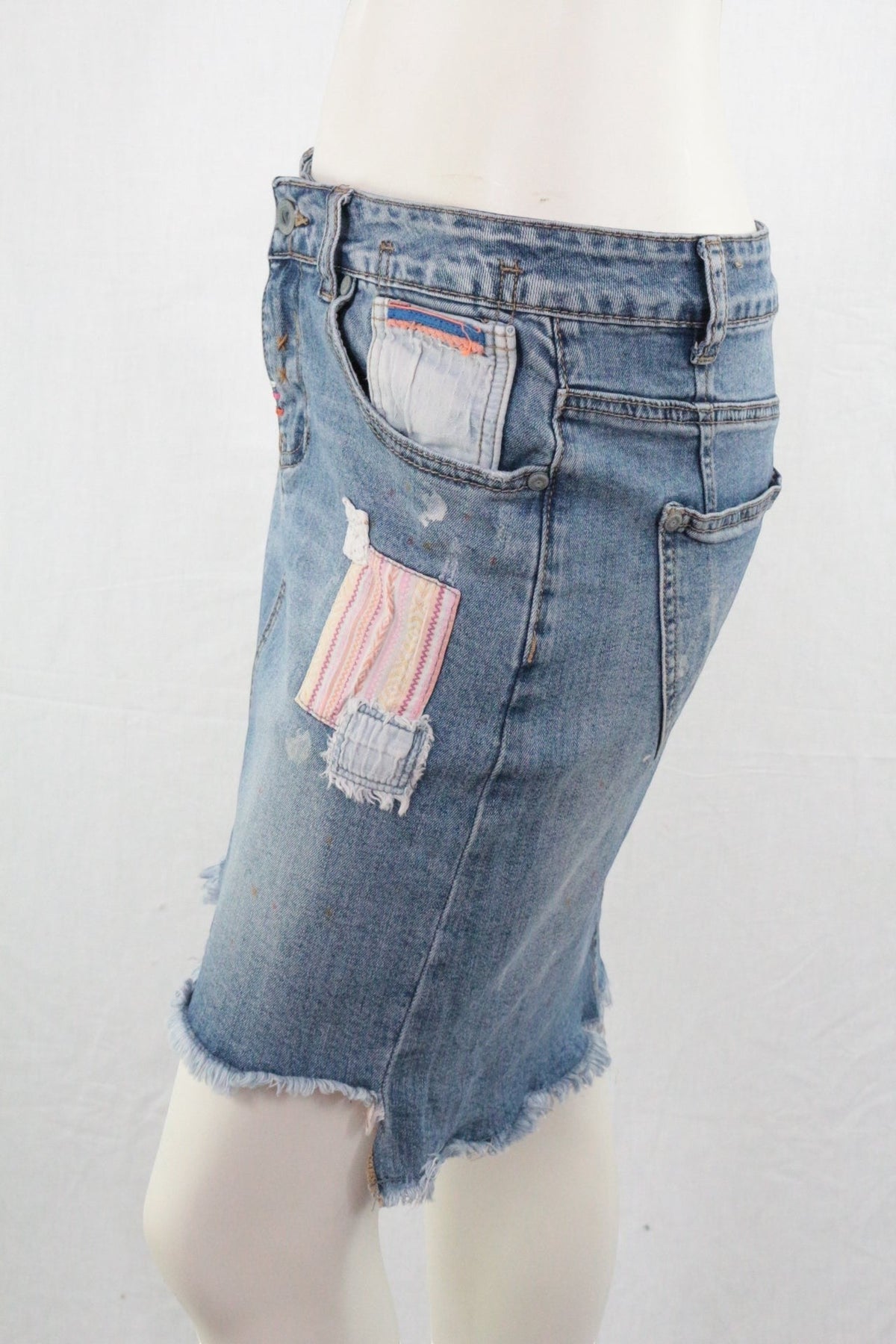Jupe courte en jean Frippindealz style bohème avec détails patchwork et finitions effilochées sur mannequin
