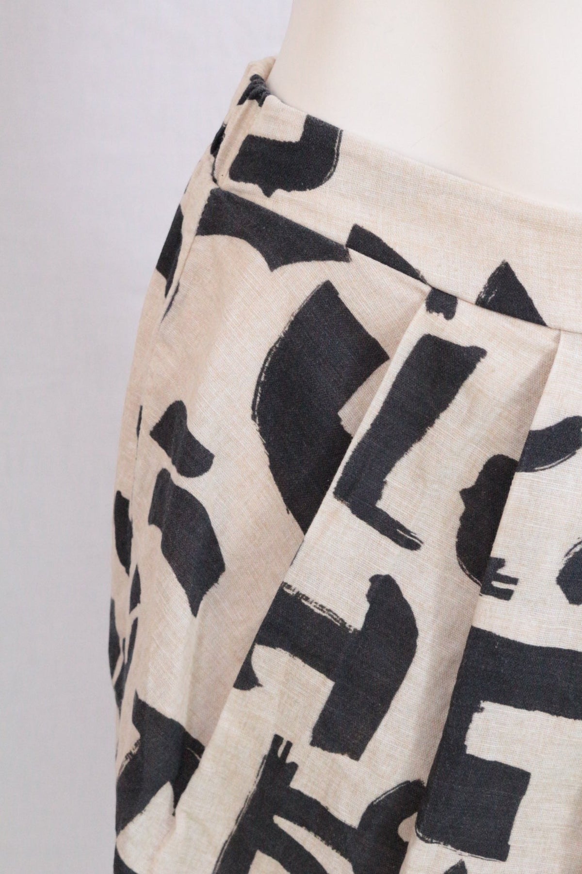 Jupe courte Frippindealz en lin et coton beige à motif abstrait noir avec une coupe ballon volumineuse
