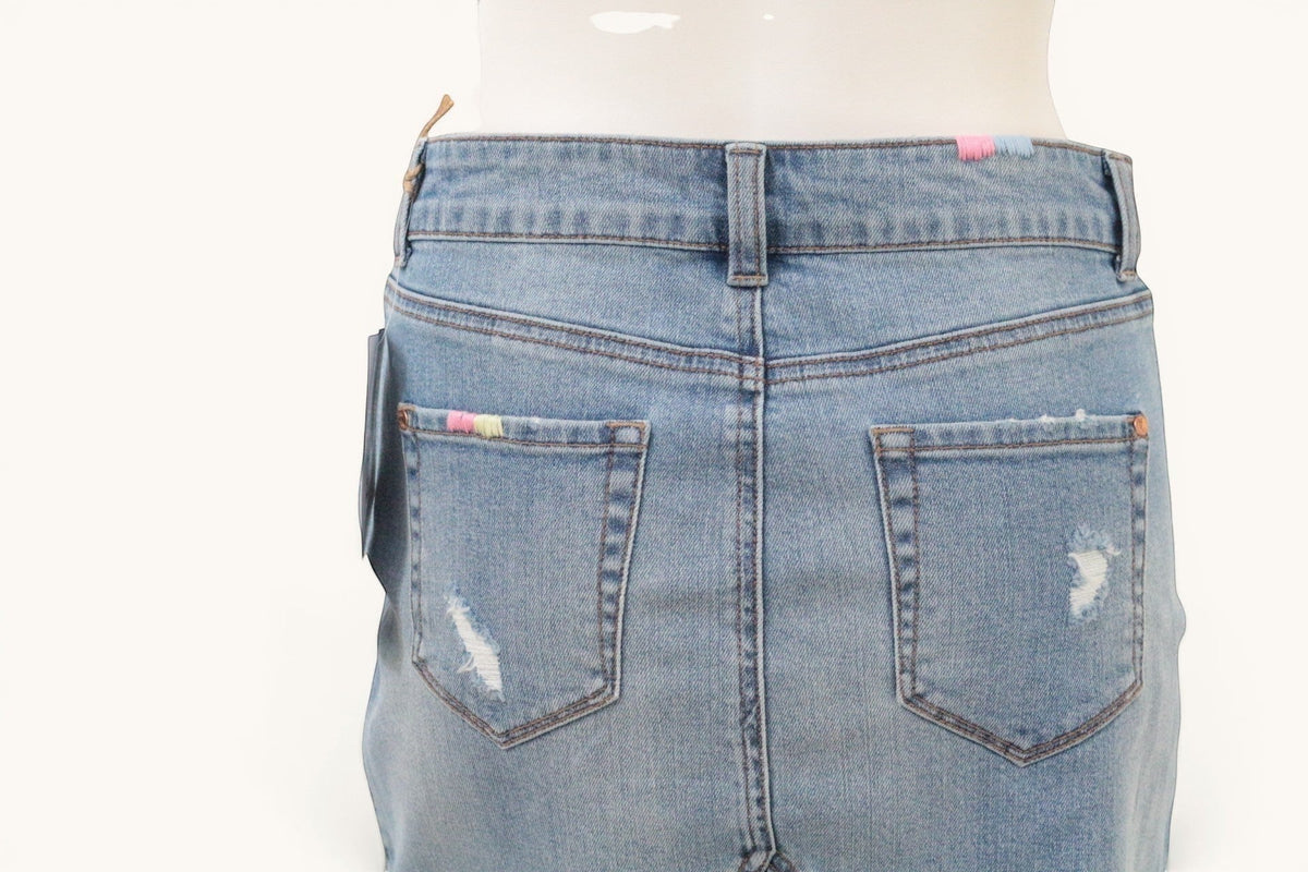 Vue arrière de la jupe en jean Frippindealz bleu clair avec broderies pastel et détails effilochés sur les poches