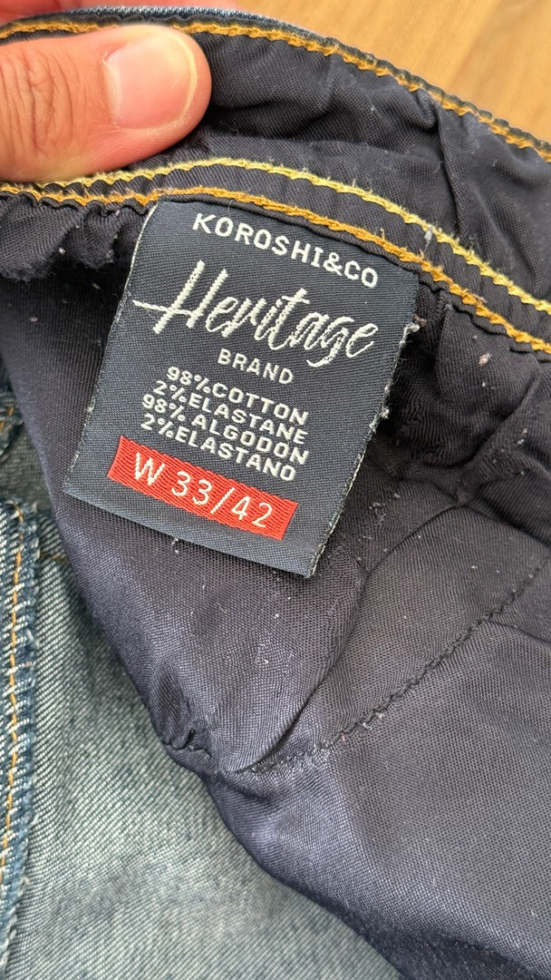 Étiquette intérieure d'un jean Frippindealz Koröshi en coton bleu avec taille W33 42 et détails de composition