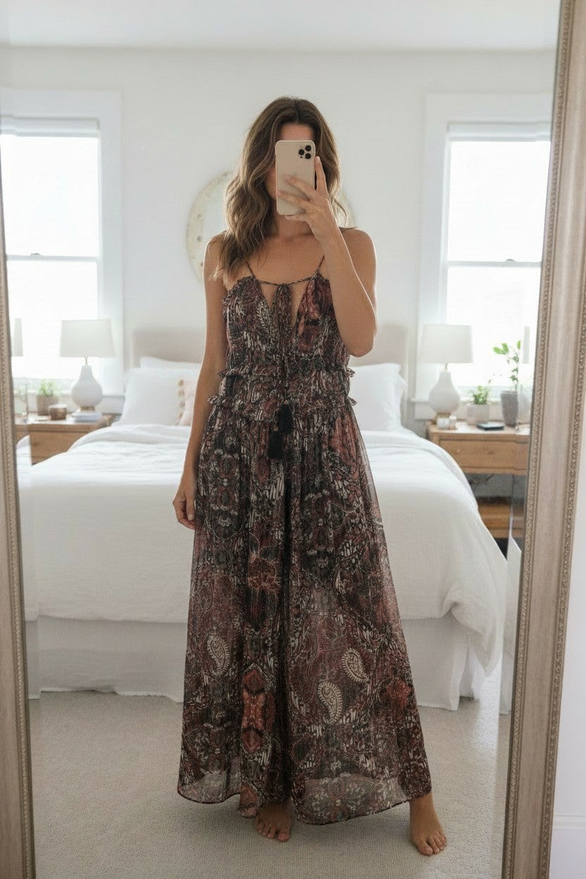 Frippindealz long viscose dress in light brown, gold, and black paisley print with tassel detail and tie-front neckline.