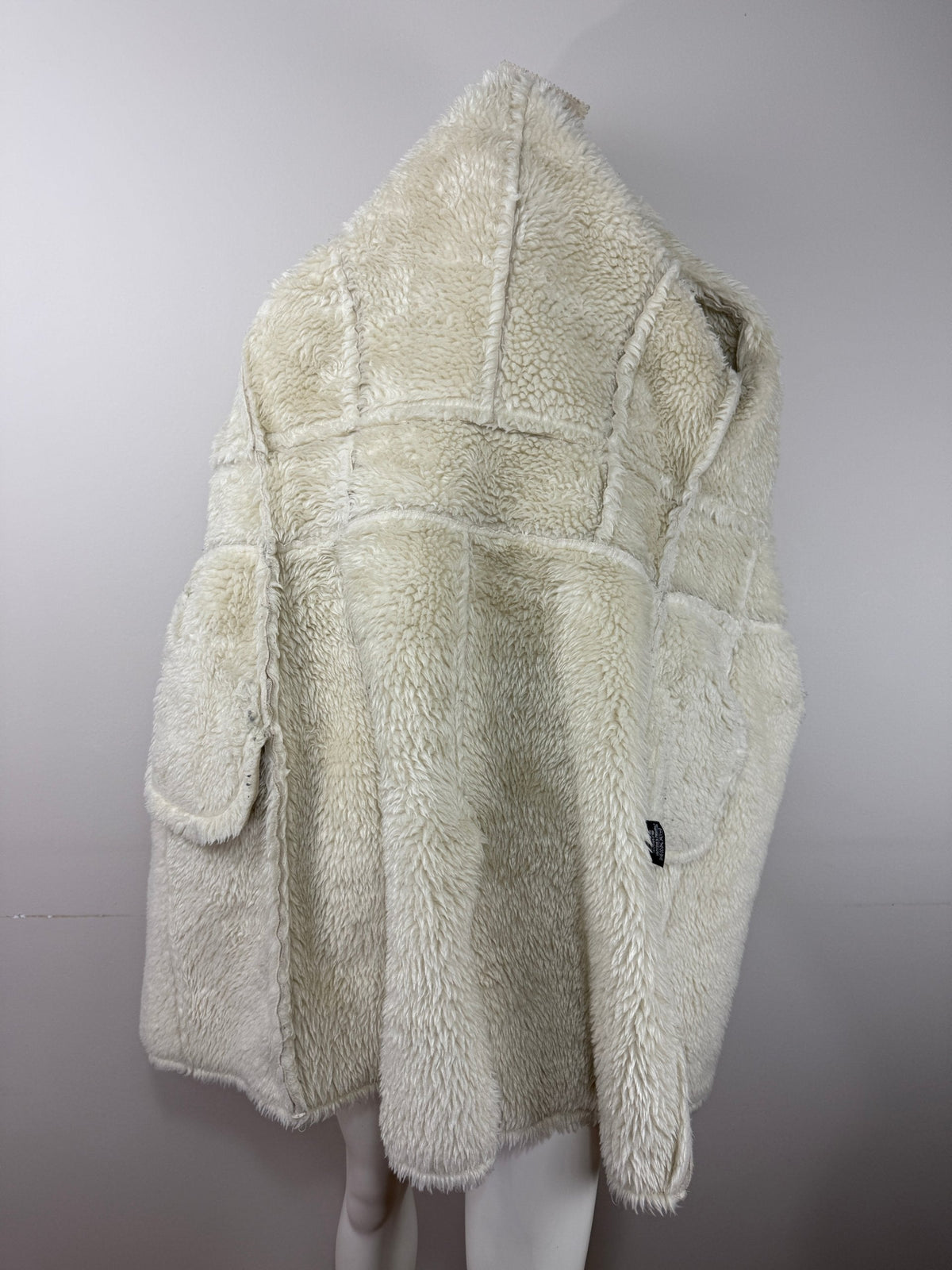 Manteau Frippindealz long en fausse fourrure blanche avec détails cloutés, idéal pour un look hivernal chic.