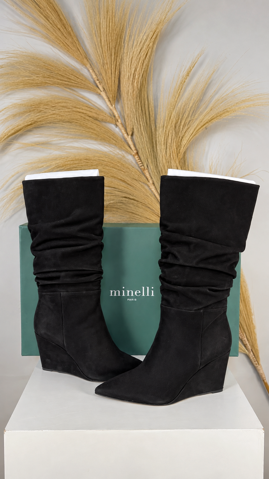 Bottes Frippindealz Minelli en nubuck noir avec talon compensé et tige froncée, présentées devant leur boîte.