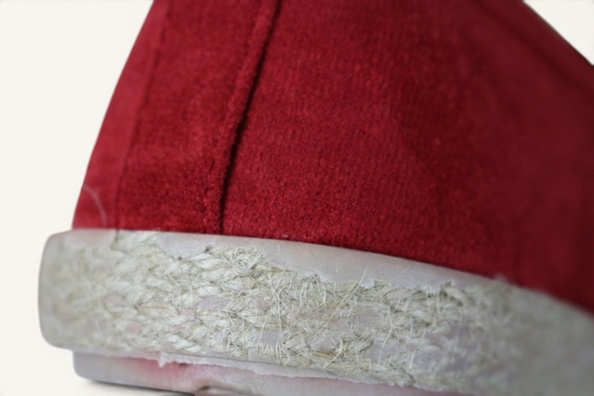 Gros plan sur un mocassin Frippindealz rouge effet daim avec une semelle texturée façon corde style espadrille