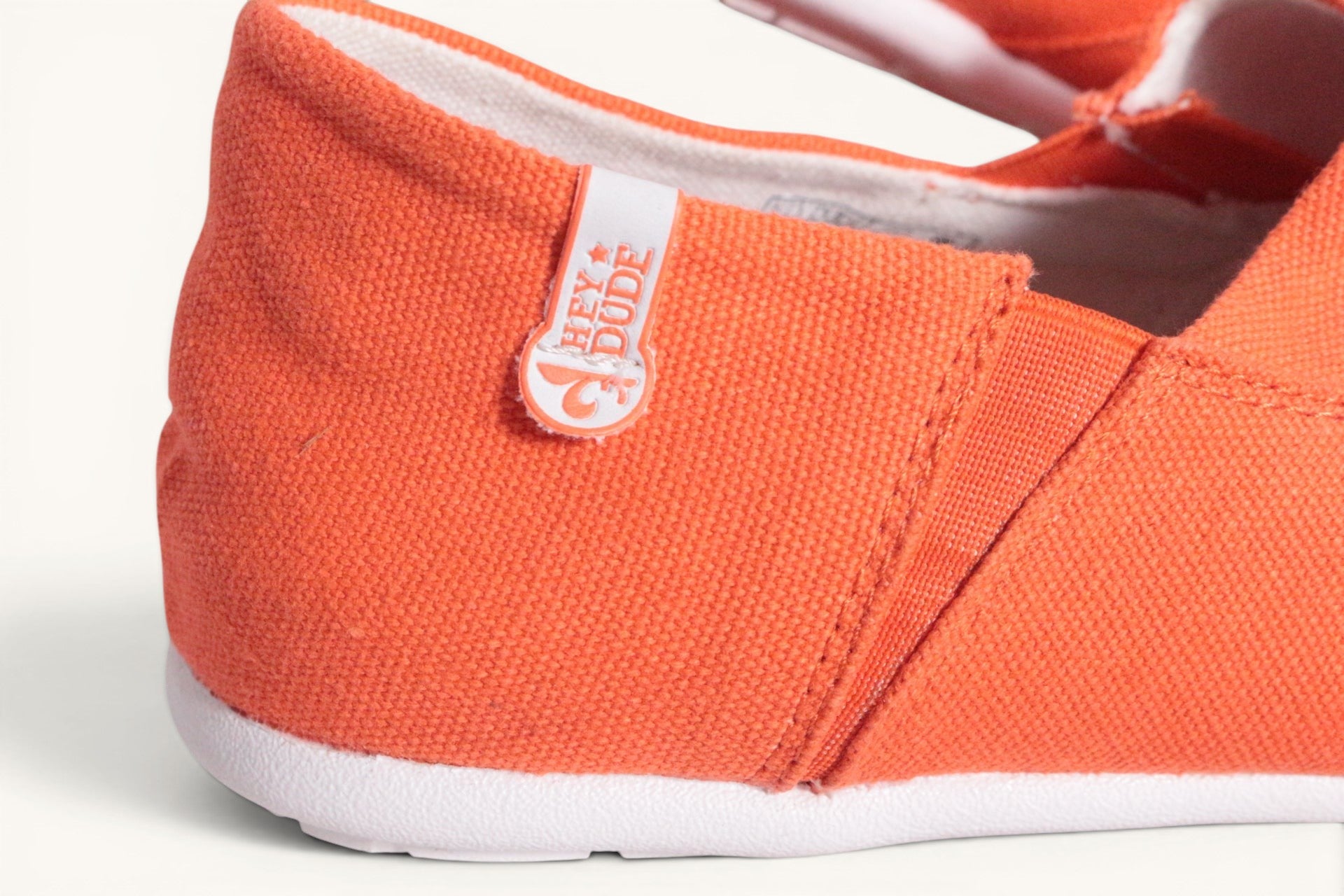 Chaussures mocassins Hey Dude en textile orange vif, légères et respirantes, avec semelle intérieure amovible.