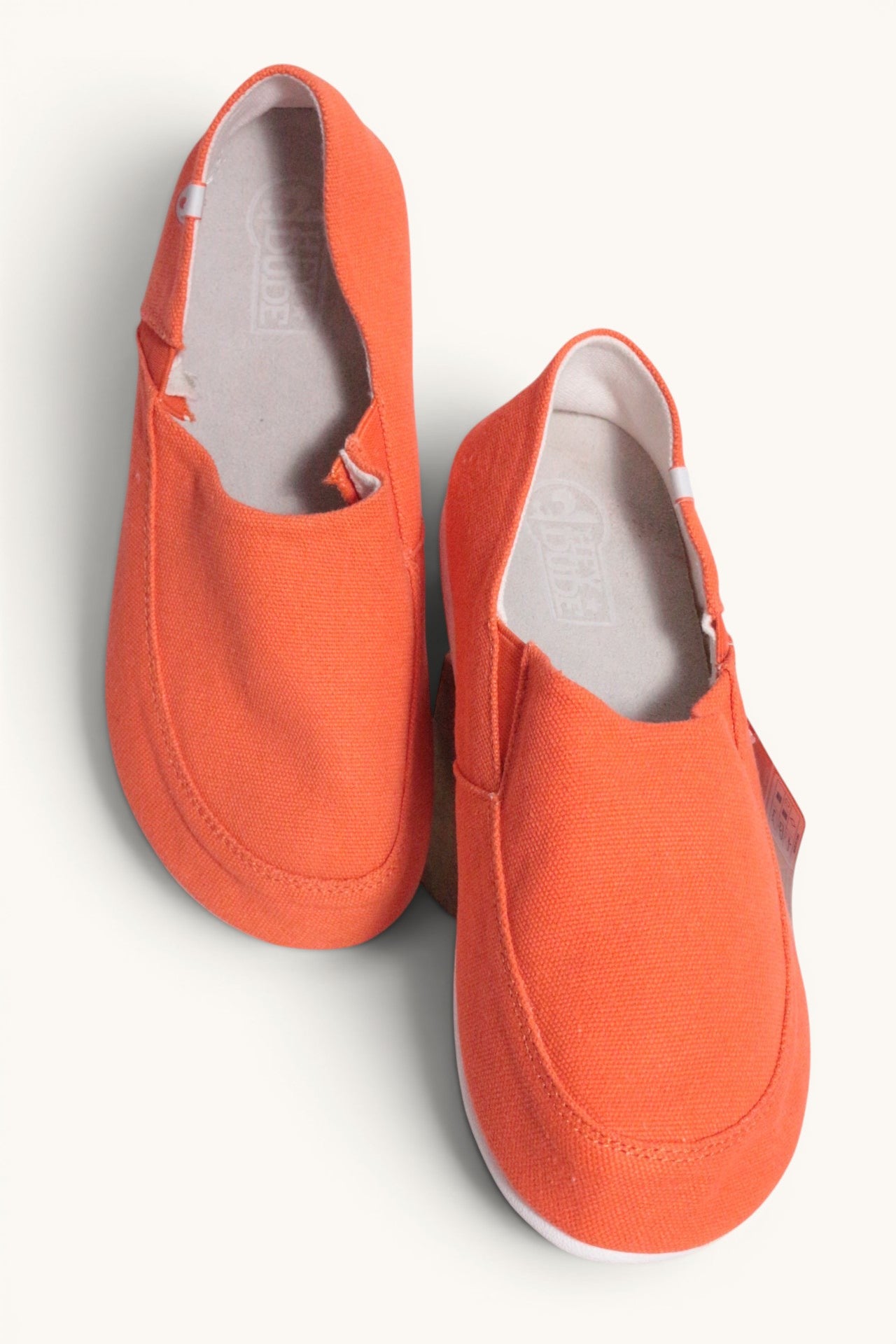 Chaussures mocassins Hey Dude orange en textile pour homme et femme, légères et confortables.