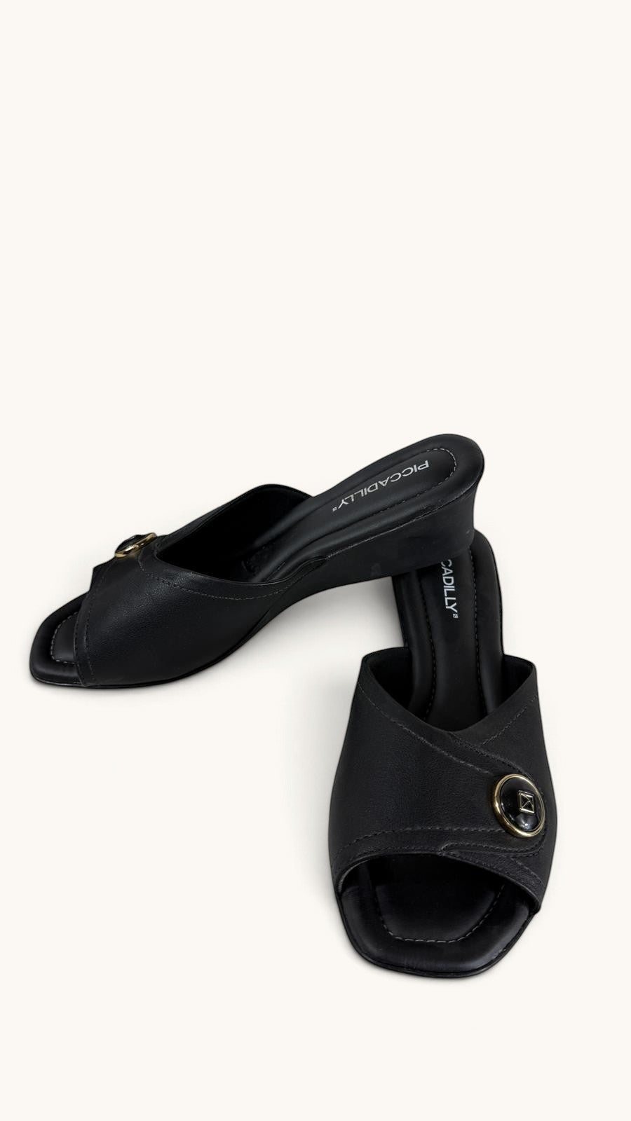 Mules compensées noires Frippindealz en simili cuir avec bride ornée d'un bouton décoratif doré et logo
