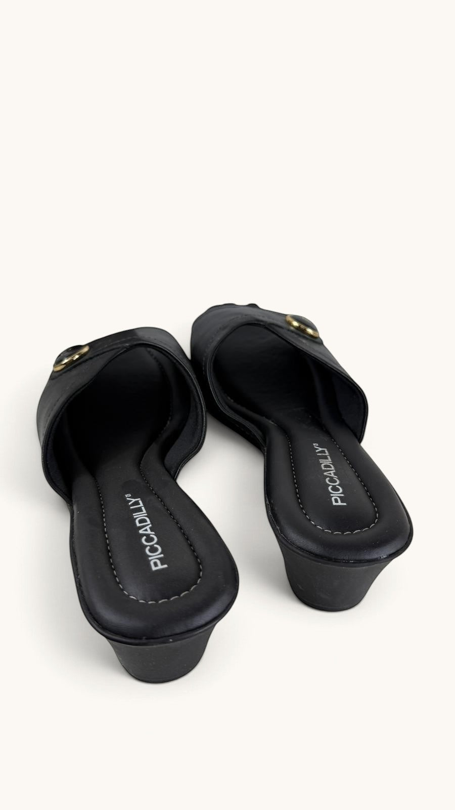 Mules compensées noires Frippindealz en simili cuir avec bride ornée d'un bouton décoratif doré et semelle matelassée