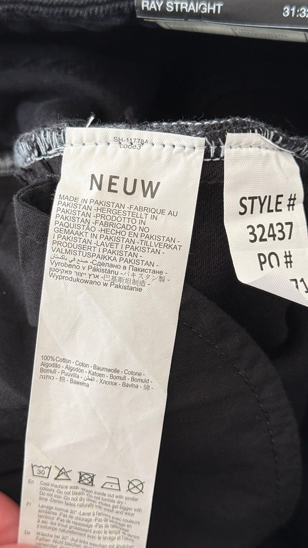 Étiquette de composition intérieure d'un jeans Frippindealz Neuw en coton noir avec instructions de lavage