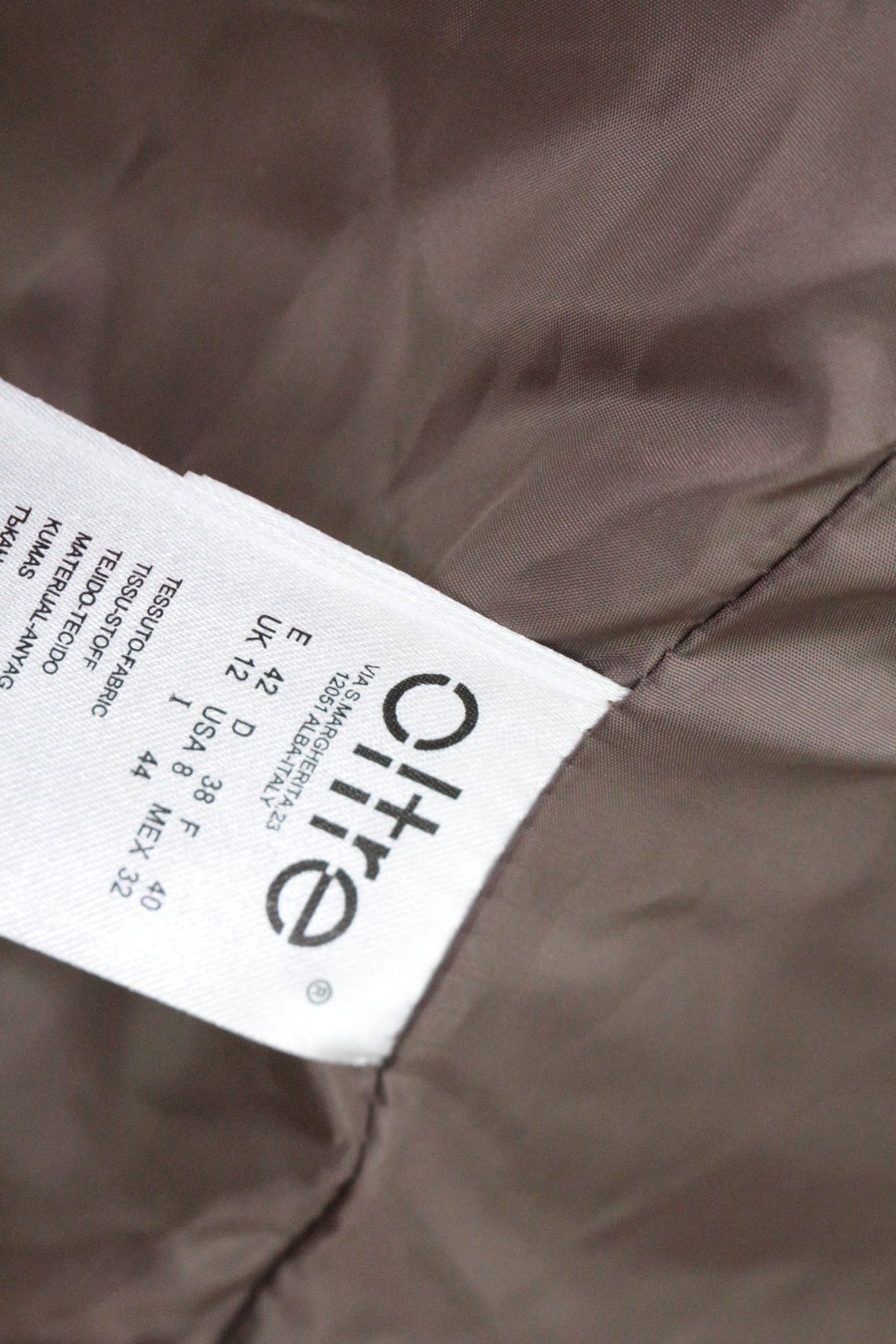 Étiquette de composition intérieure du manteau beige Frippindealz Oltre avec détails des tailles internationales
