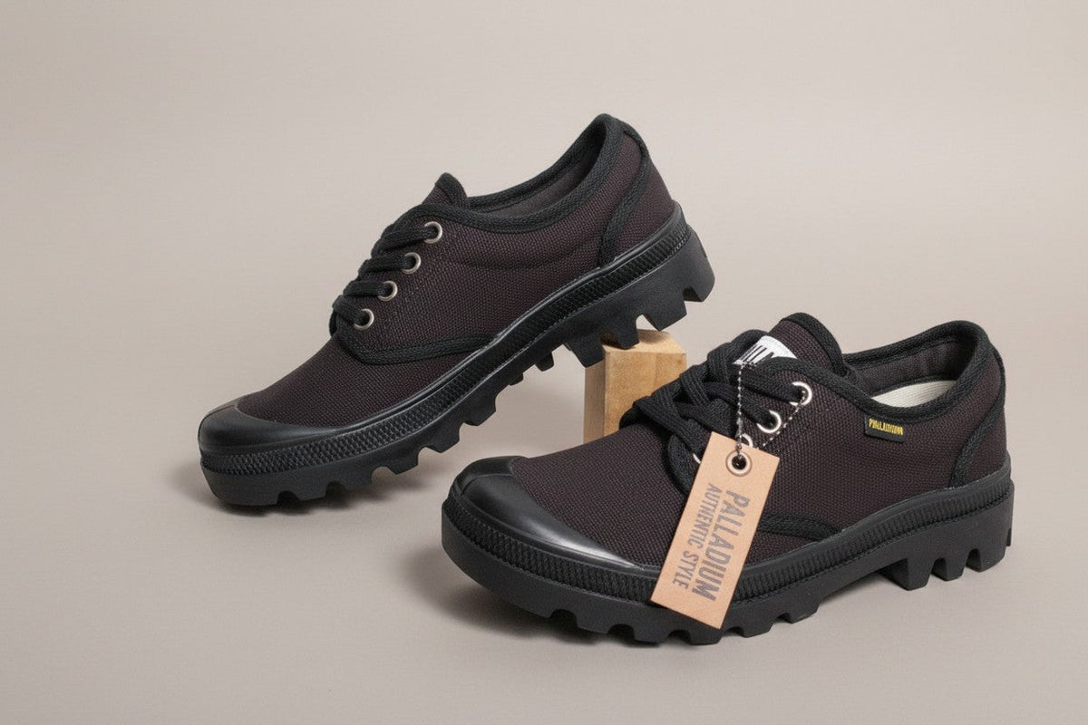Frippindealz Palladium black canvas low-top sneakers with lace-up closure and thick rubber sole.