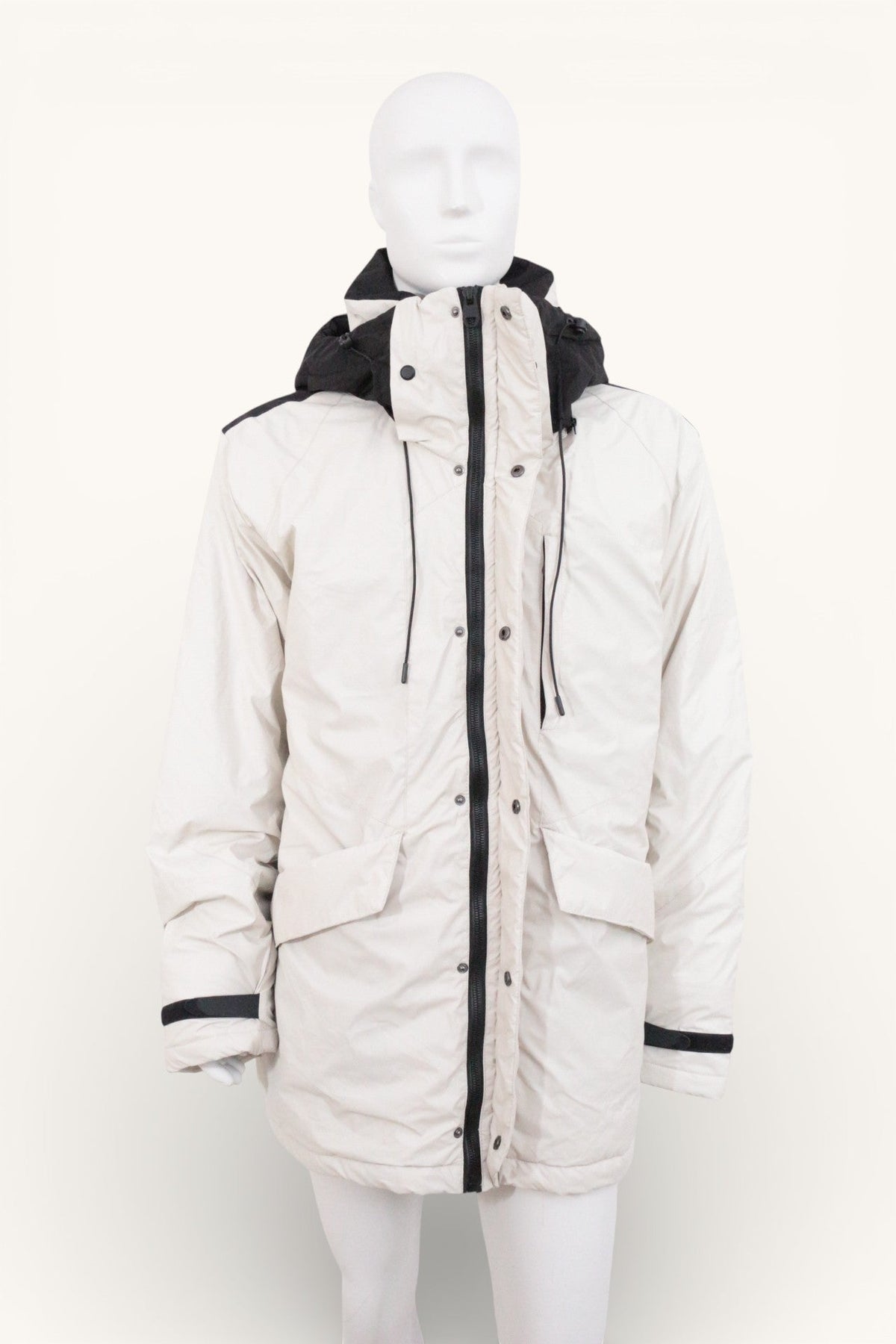 Parka Frippindealz blanche et noire en polyester avec capuche, fermeture zippée et poches, style hivernal moderne.