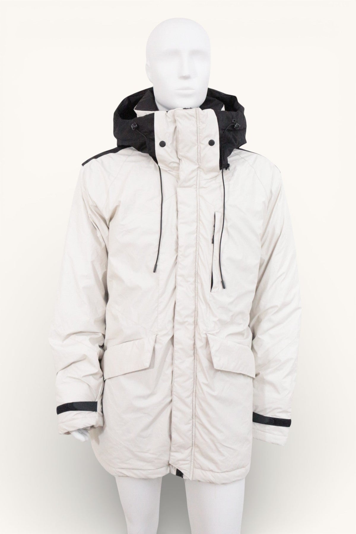 Parka Frippindealz en polyester blanc et noir avec capuche intégrée et poches frontales, style hivernal moderne.