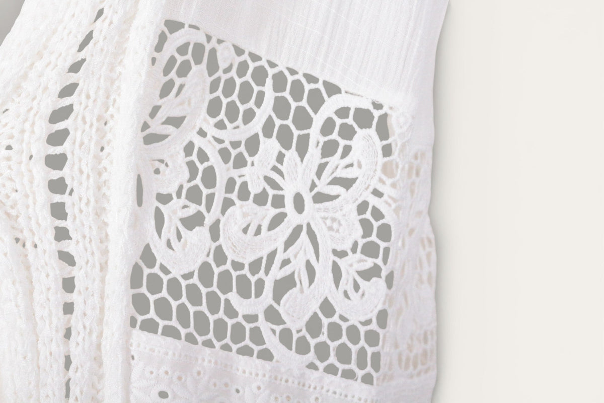Détail de la dentelle florale aérienne sur le poncho crème Frippindealz en viscose