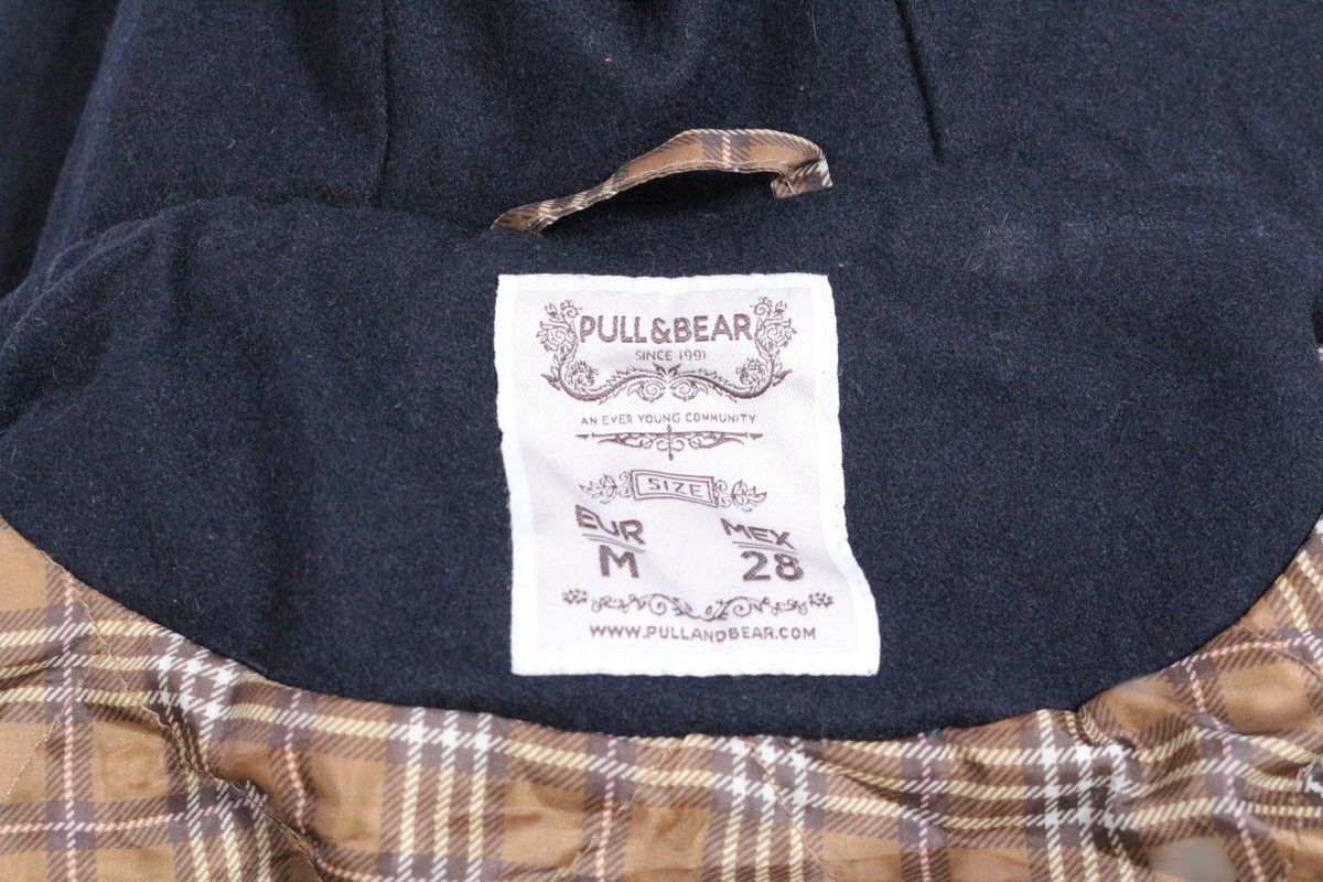 Étiquette intérieure Frippindealz d'un duffle-coat Pull&Bear bleu marine en laine avec doublure à carreaux marron
