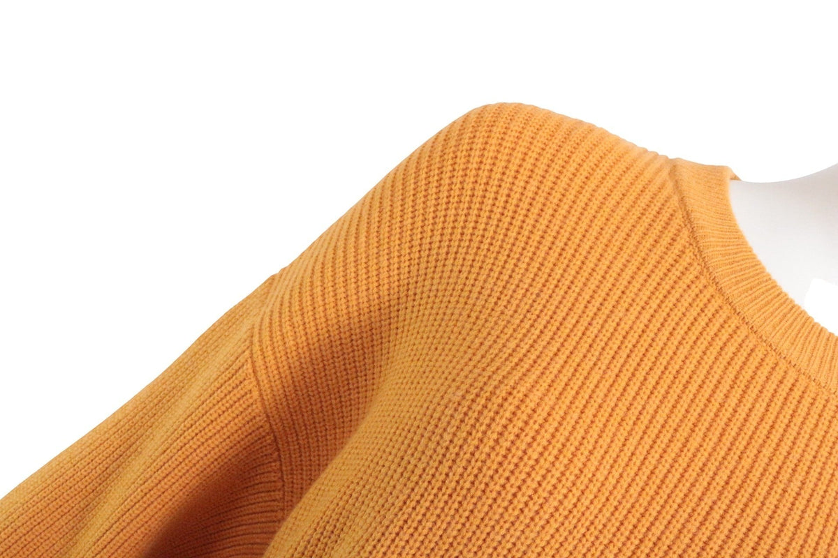 Gros plan sur l'épaule d'un pull Zara orange en maille côtelée, disponible chez Frippindealz.