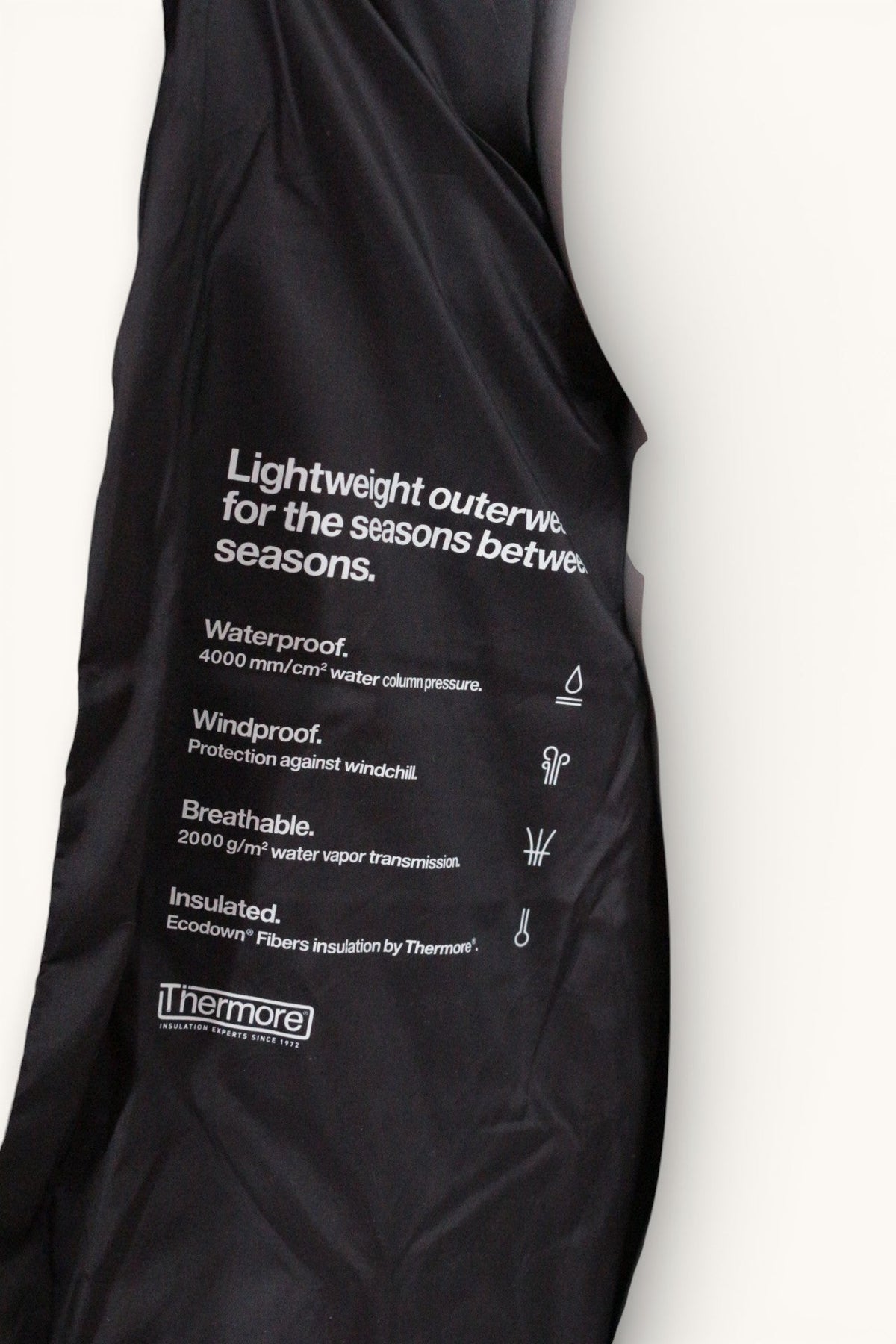 Détail de l'étiquette intérieure d'une doudoune noire Frippindealz Rains avec caractéristiques techniques