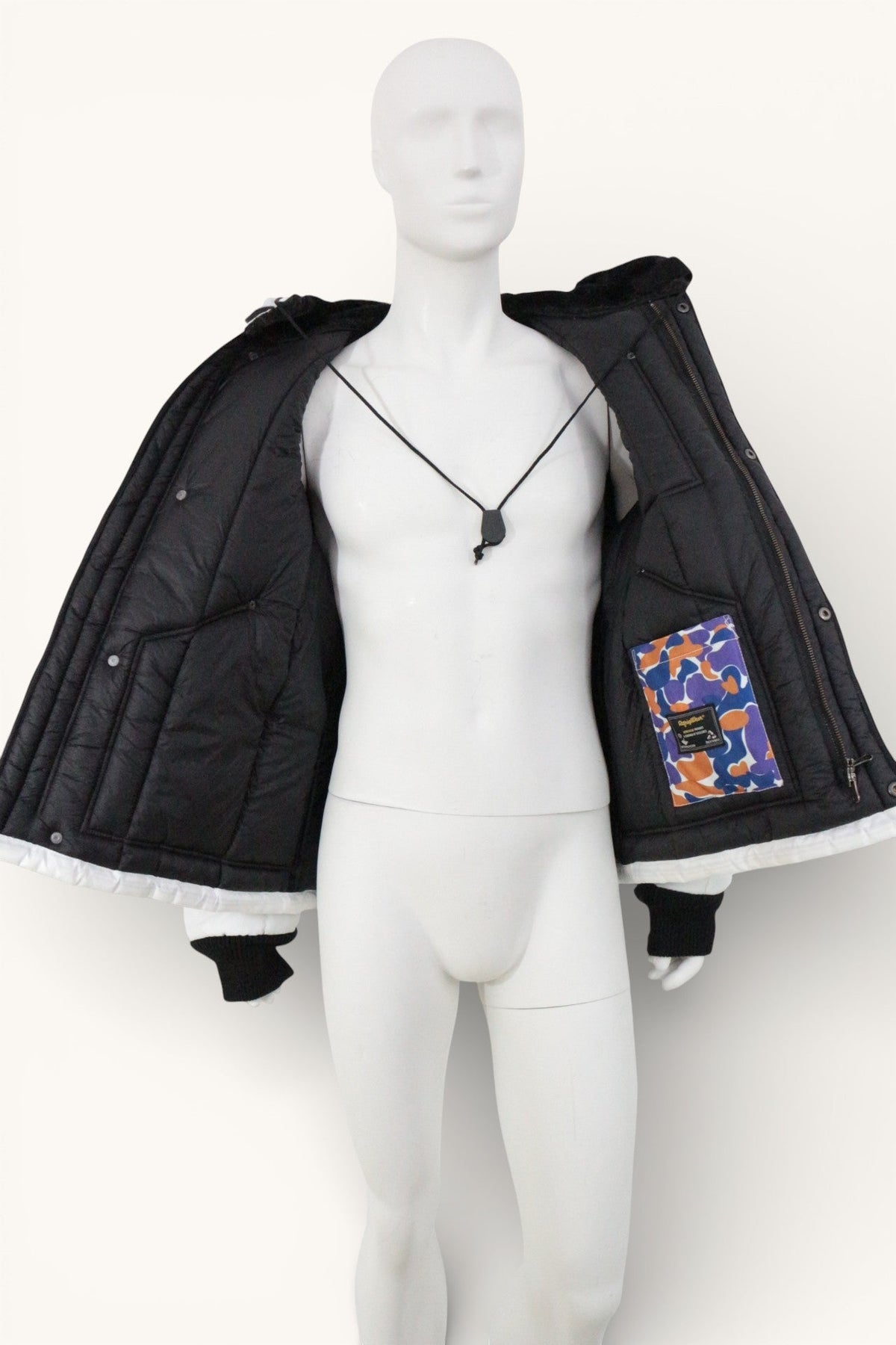 Veste d'hiver Frippindealz Refrigiwear noire avec doublure intérieure multicolore et poches contrastées sur mannequin