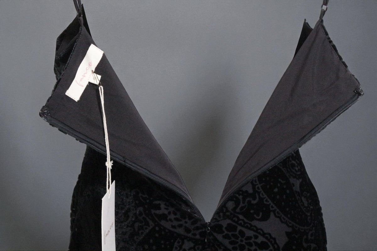 Robe courte noire Fanco en polyester avec détails texturés, vue rapprochée de la fermeture éclair et de l'étiquette