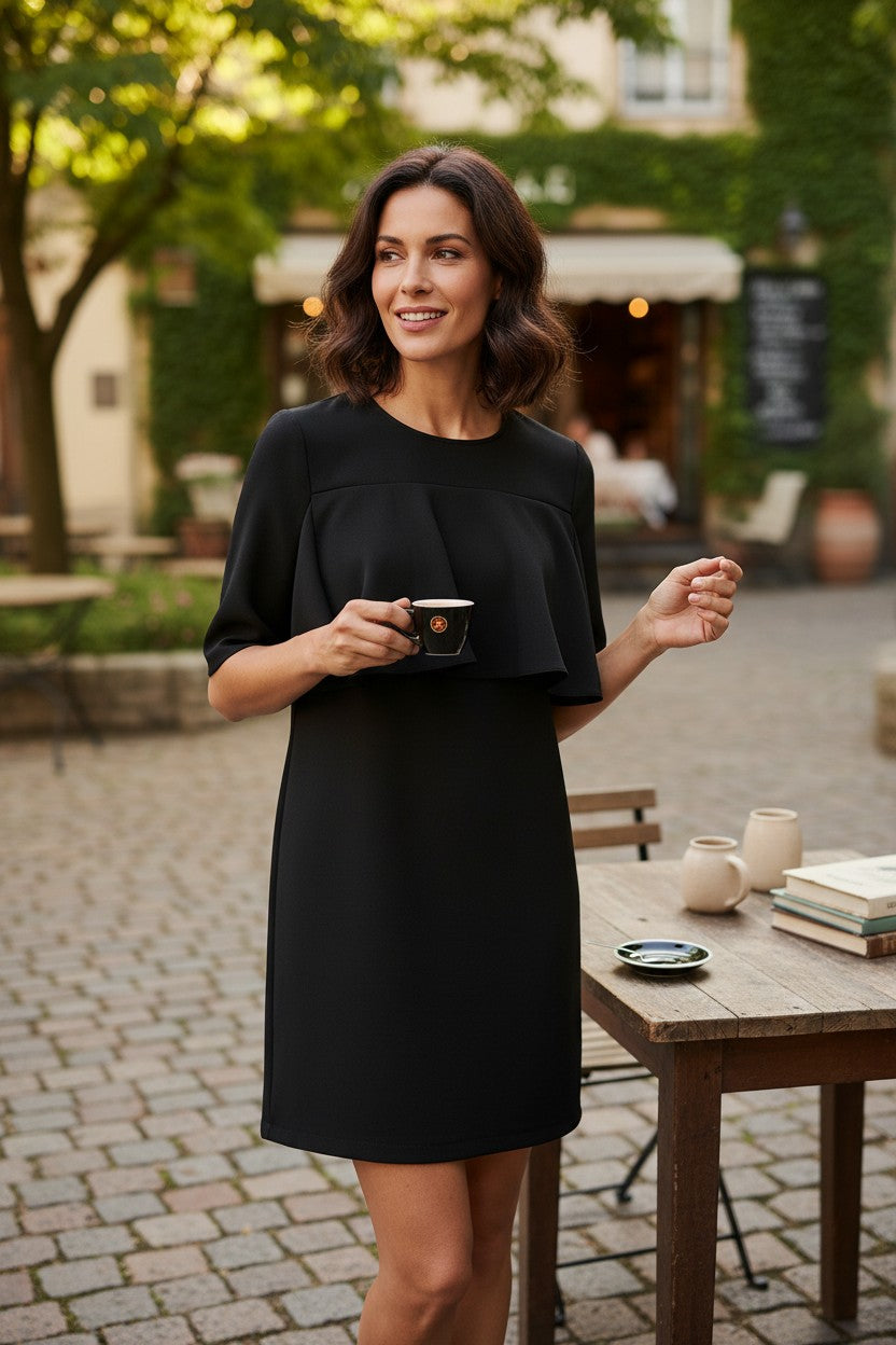 Femme portant une robe courte noire Frippindealz Mango avec empiècement volanté sur le buste en terrasse