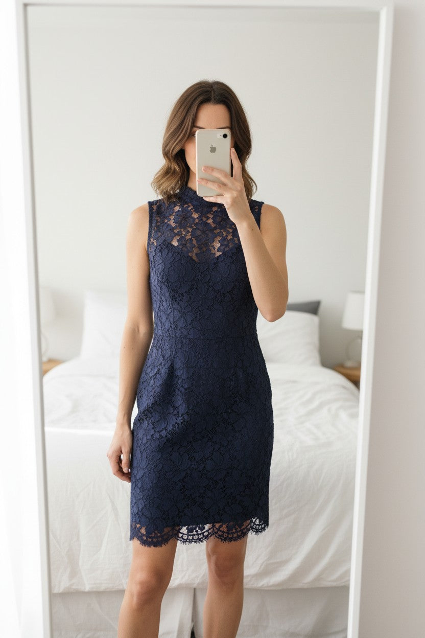 Robe Sandro mi-longue en dentelle bleu marine, sans manches, col montant, idéale pour soirées élégantes.