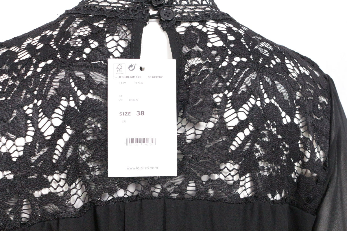 Détail du haut en dentelle noire Lolaliza avec étiquette de prix, coupe élégante et fermeture à boutons au dos