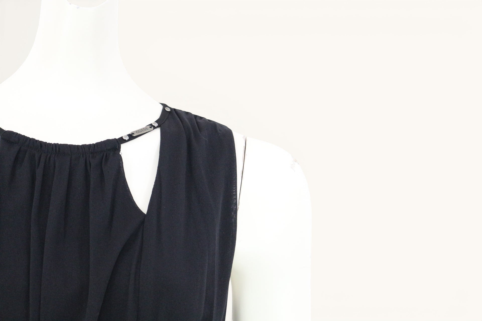 Robe noire Guess fluide sans manches, taille élastiquée, détails bijoux aux épaules, taille S. Idéale pour soirée ou cocktail.