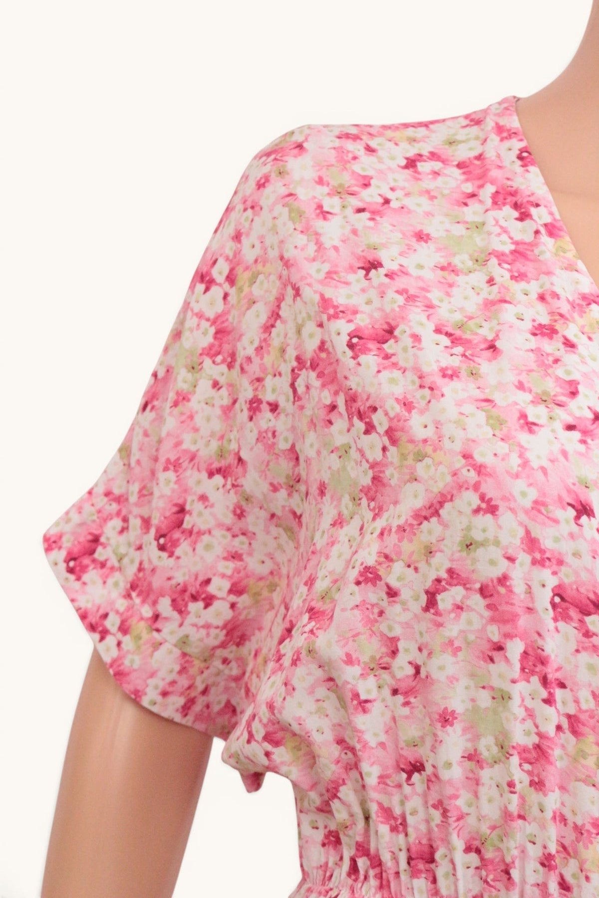 Gros plan sur le décolleté cache-cœur et les manches fluides de la robe longue Frippindealz en viscose à fleurs roses
