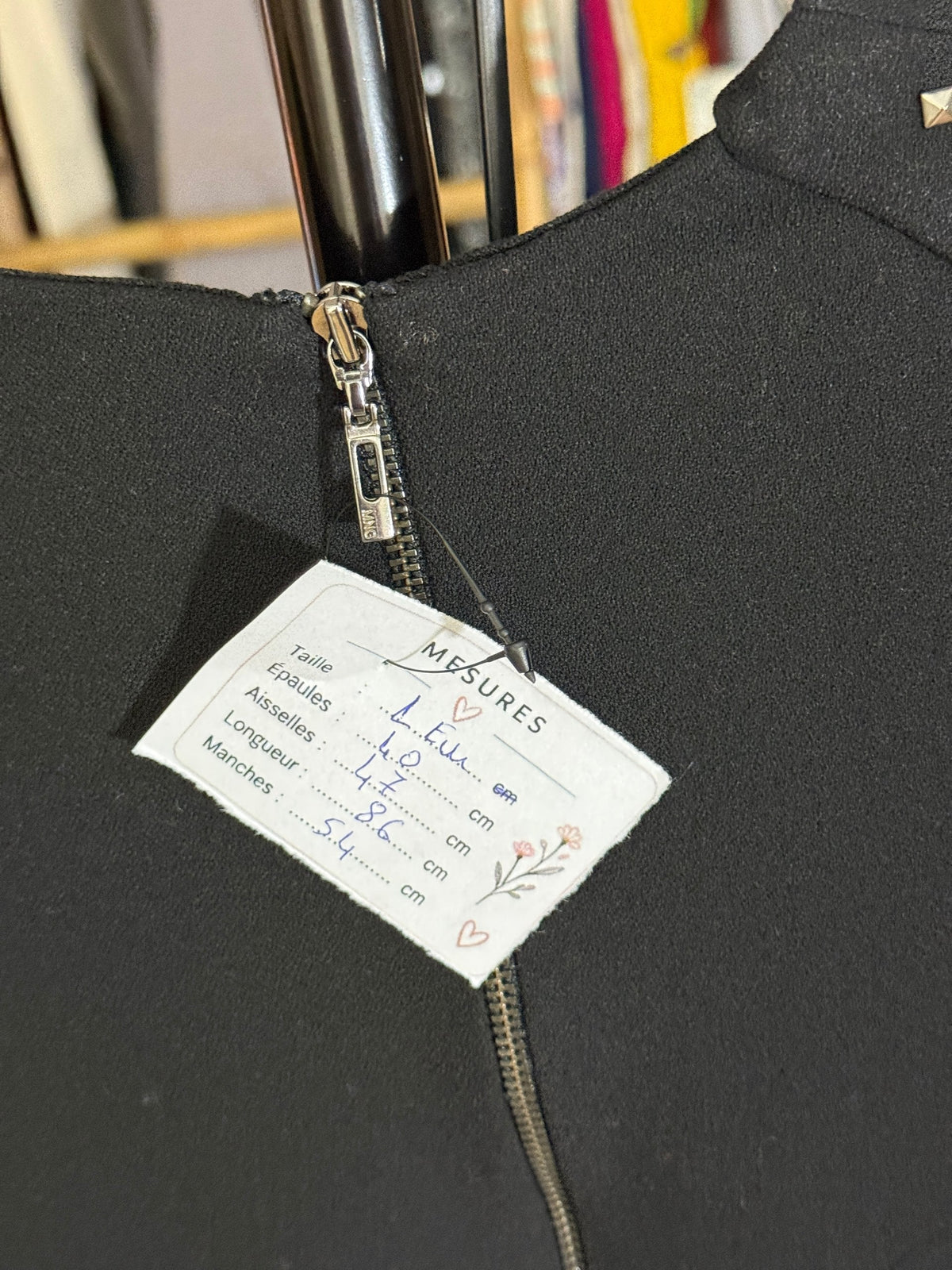 Étiquette de mesures Frippindealz sur une robe noire à manches longues avec fermeture éclair au dos