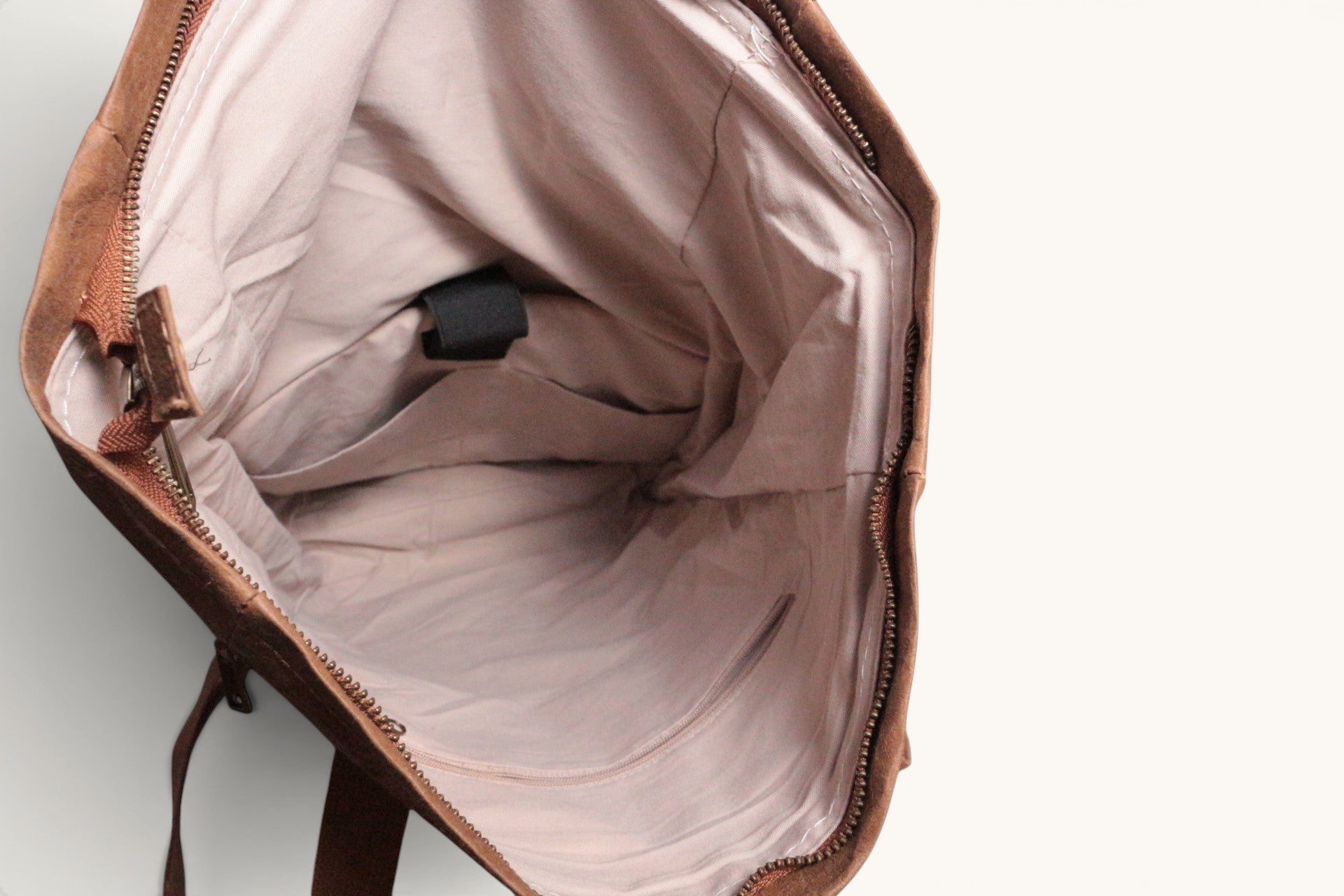 Sac à dos Nordlicht Frippindealz en cuir marron, intérieur doublé avec poches et compartiment pour ordinateur portable.