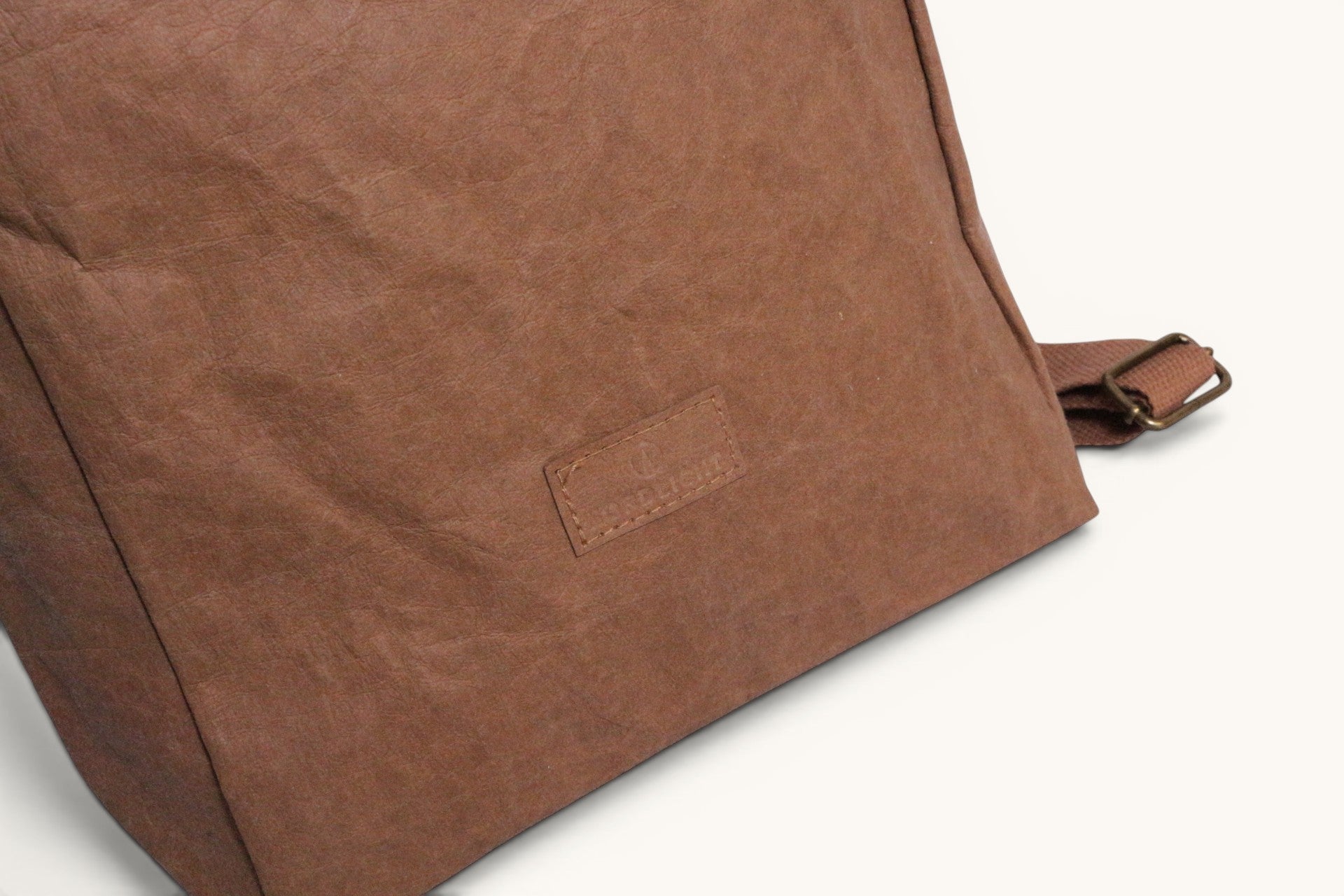 Sac à dos Nordlicht en papier marron avec une étiquette logo cousue. Bretelle réglable en tissu marron.