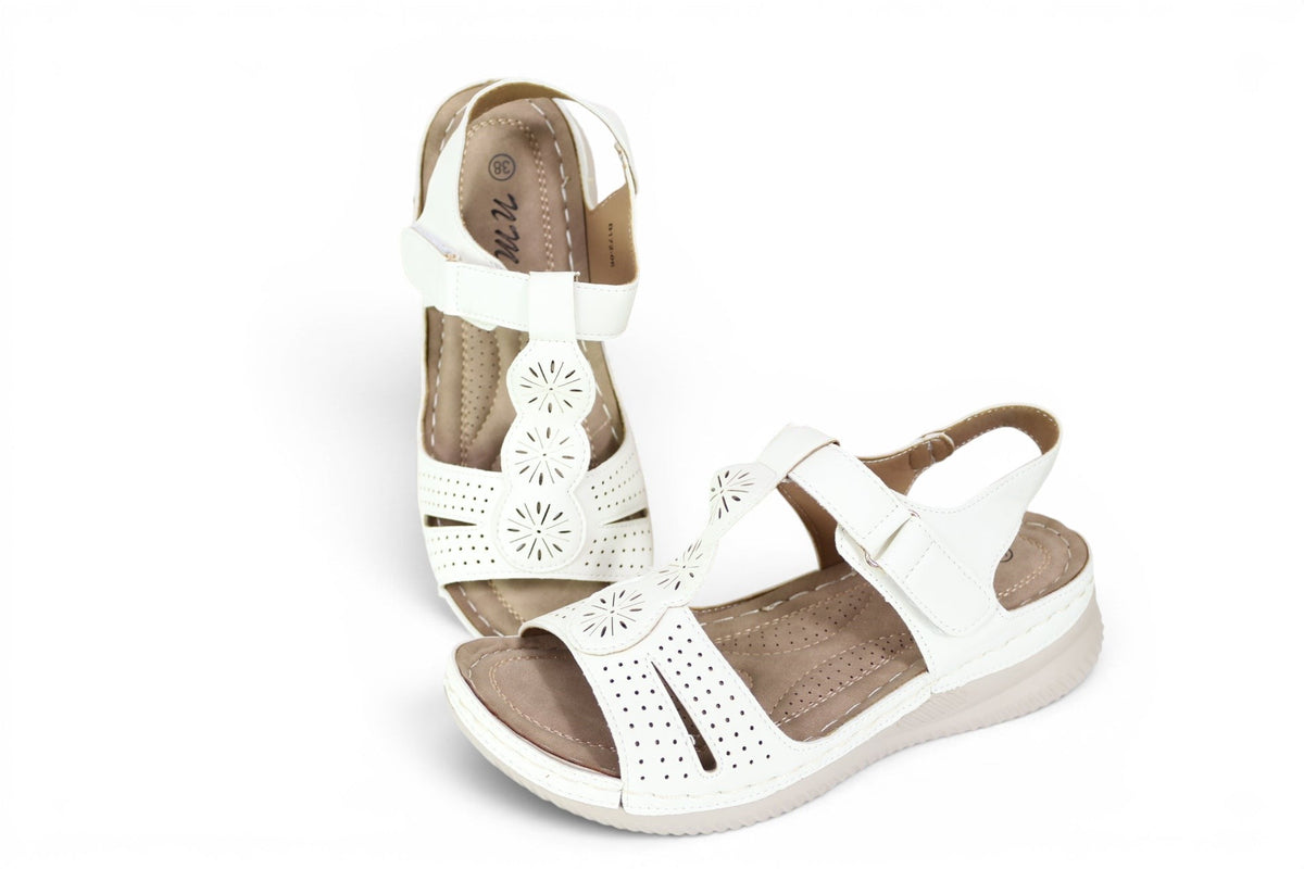 Sandales confort femme Frippindealz blanches avec bride ajustable, semelle compensée et détails floraux ajourés.