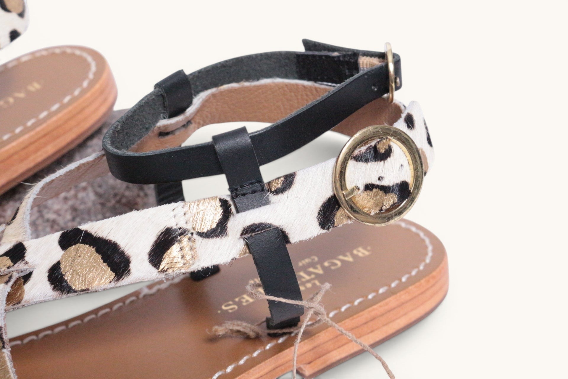 Frippindealz Sandales plates en cuir avec imprimé léopard noir et doré, et brides noires. Taille 40.