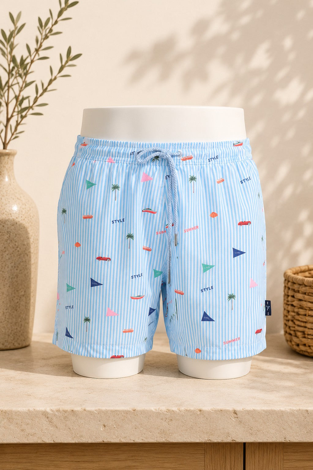Short de bain Frippindealz Bruce & Butler rayé bleu ciel et blanc avec motifs estivaux, taille élastique et cordon.