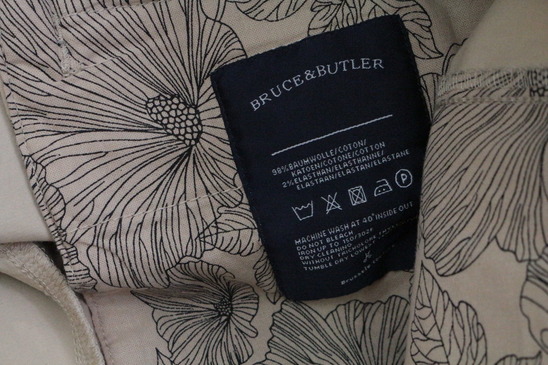 Étiquette intérieure Frippindealz du short cargo Bruce & Butler beige en coton stretch avec motif floral raffiné