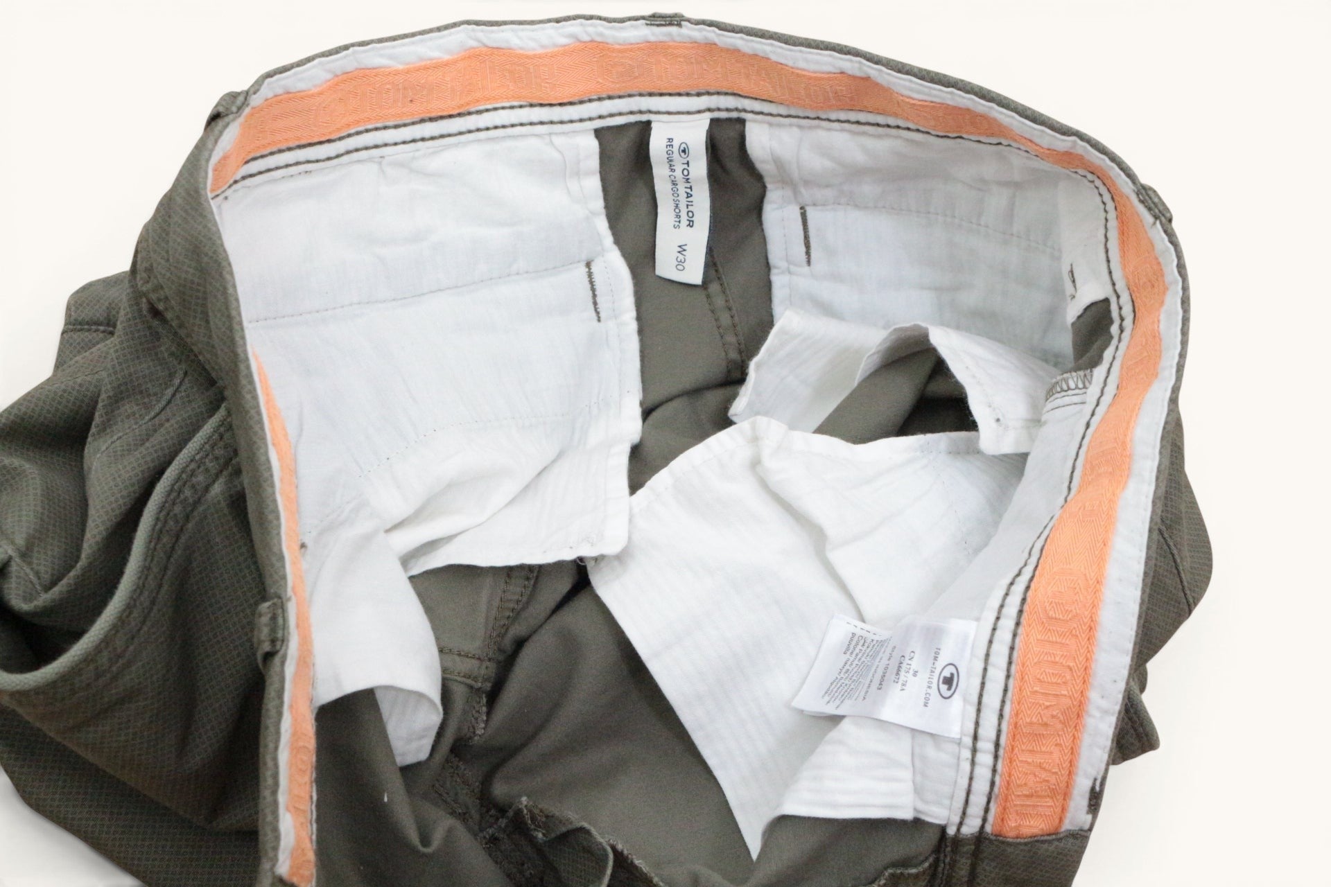 Intérieur d'un short cargo Frippindealz Tom Tailor vert kaki en coton stretch avec doublure orange et étiquette W30.