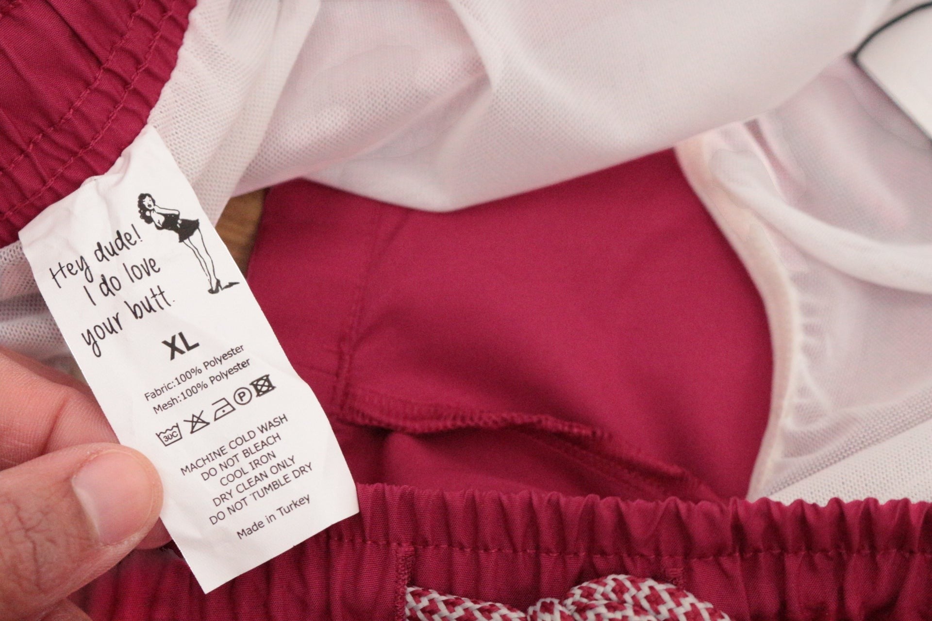 Étiquette intérieure d'un short de bain Frippindealz Bruce & Butler bordeaux en polyester avec doublure mesh, taille XL