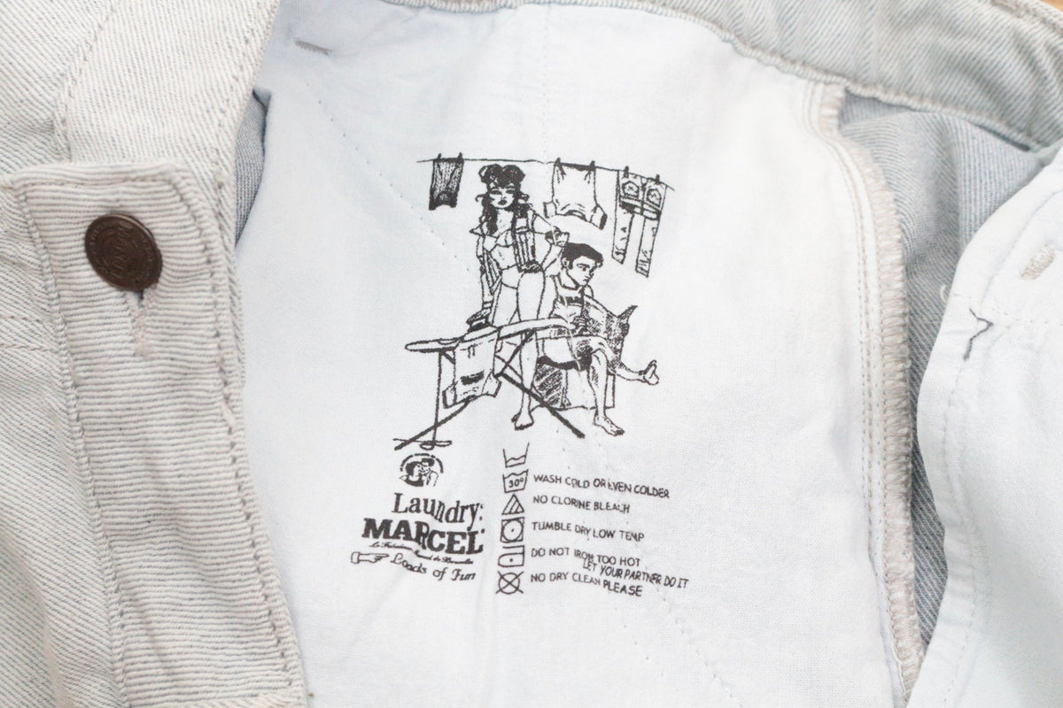 Détail intérieur du short en jean Marcel Bruxelles Simon Denim bleu clair avec étiquette de lavage illustrée