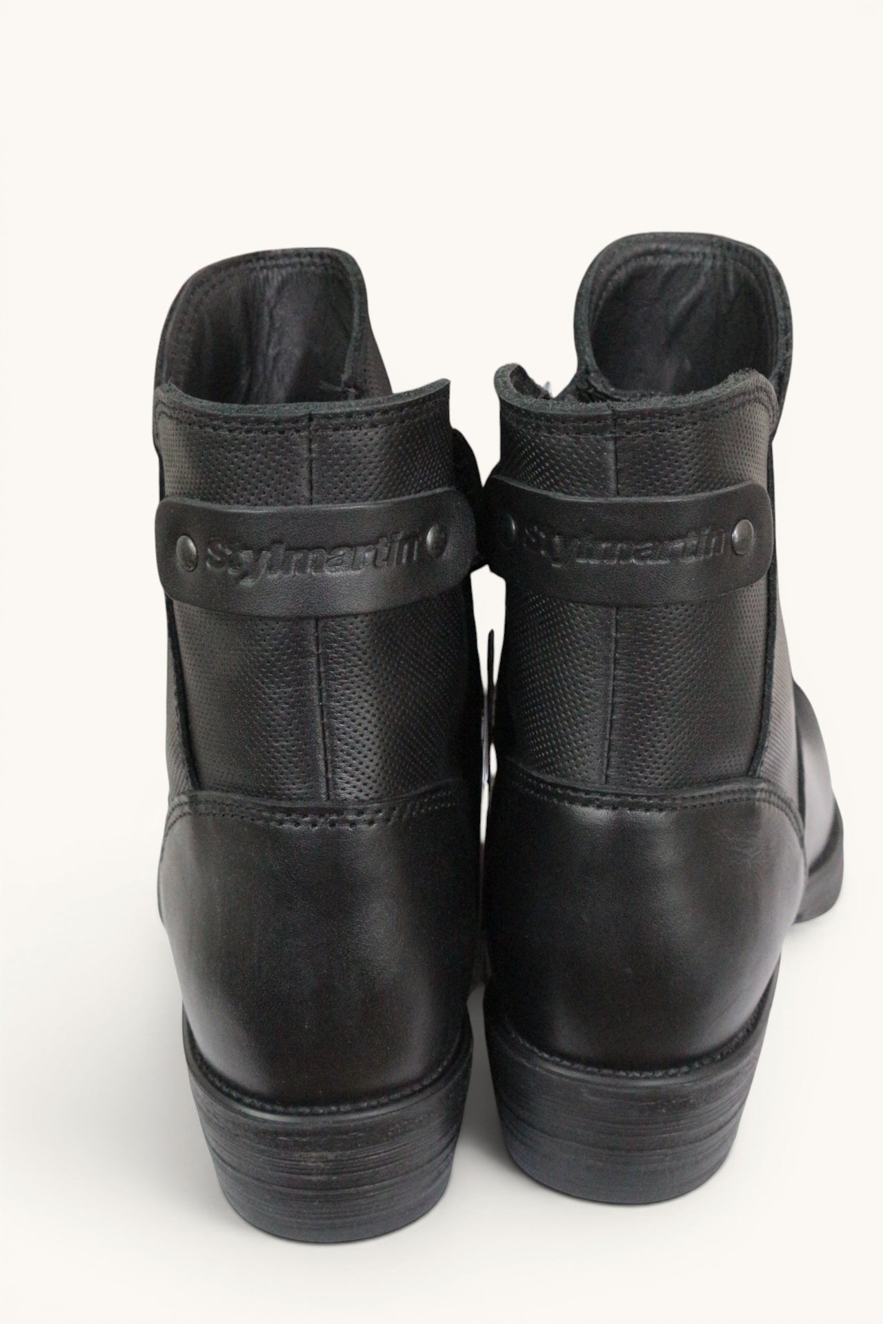 Vue arrière des bottines moto femme Frippindealz Stylmartin noires en cuir avec logo embossé et talon bas