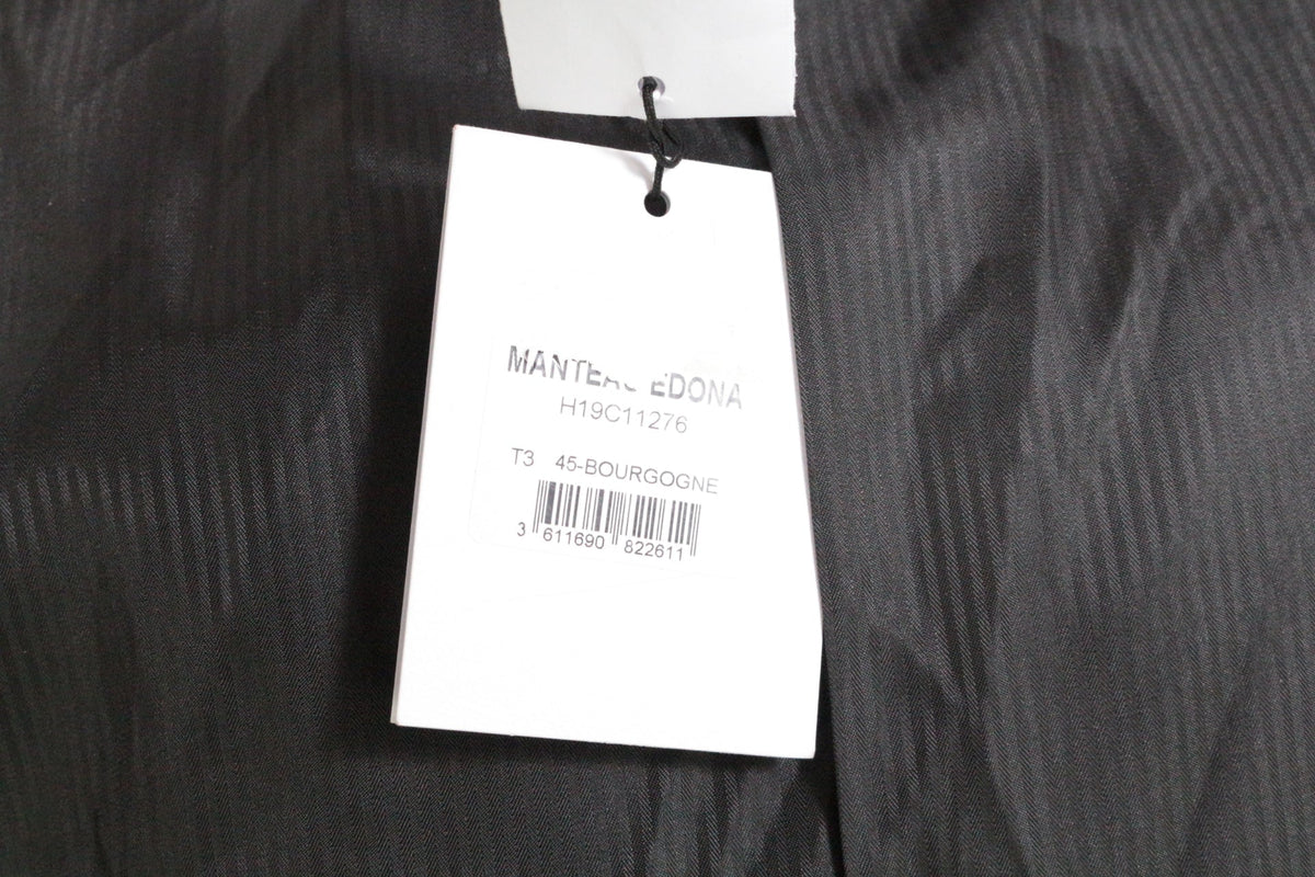 Étiquette de prix blanche sur manteau bordeaux Frippindealz avec détails de la marque Suncoo et code-barres