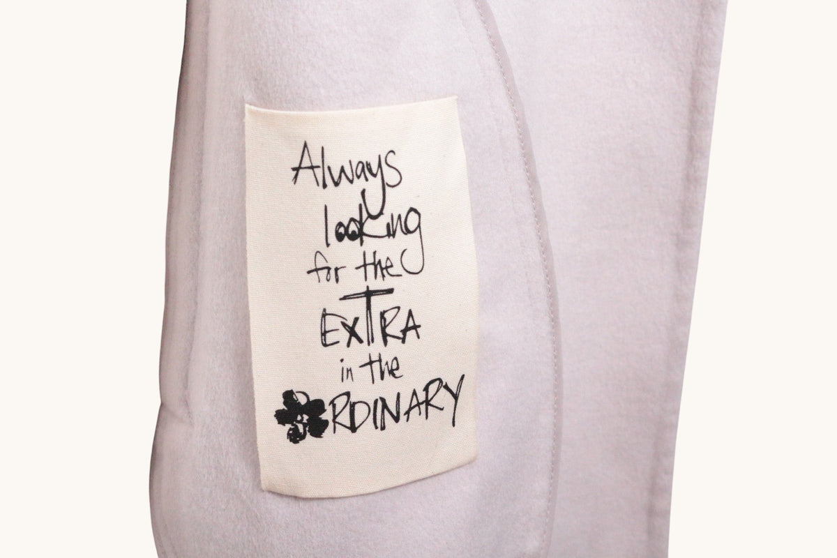 Détail de l'étiquette Frippindealz sur un manteau beige en laine Ted Baker avec inscription manuscrite