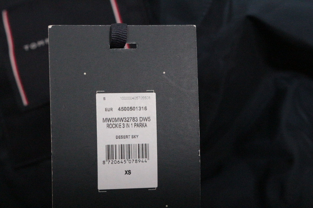 Étiquette de prix et informations produit sur une parka Frippindealz Tommy Hilfiger bleu marine