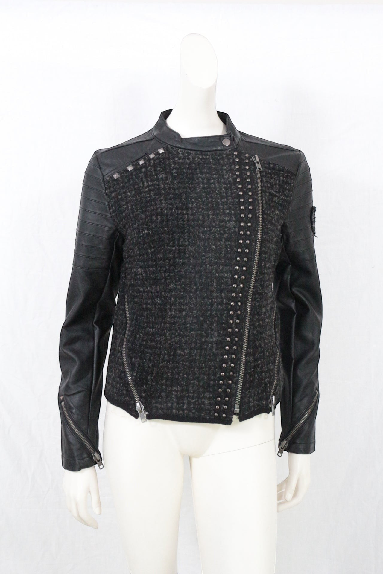 Veste biker Frippindealz en tweed noir/gris et simili cuir, zippée asymétrique, cloutée, manches matelassées.