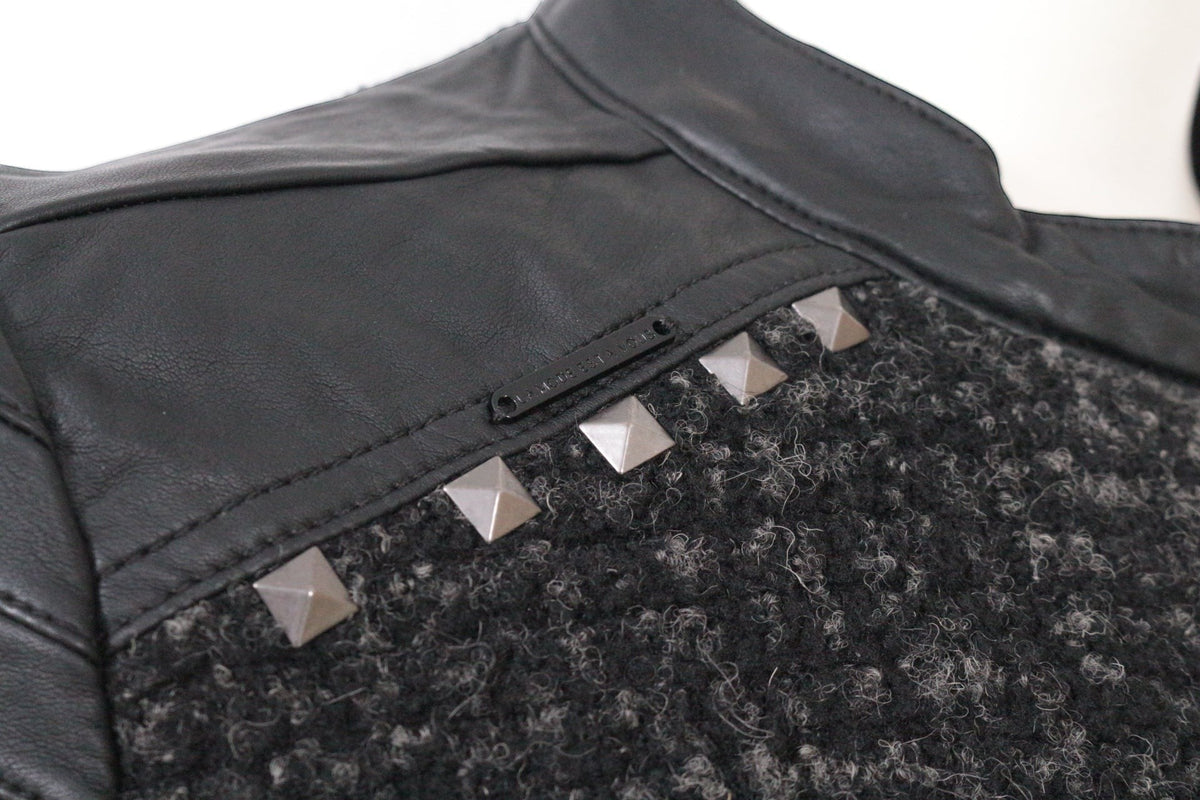 Gros plan Frippindealz sur veste biker en tweed noir et gris avec empiècements en simili cuir et clous métalliques