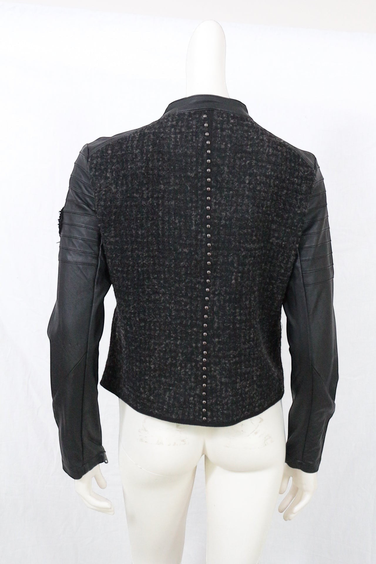Frippindealz Veste biker noire en tweed texturé et simili cuir clouté, zip asymétrique, manches matelassées.