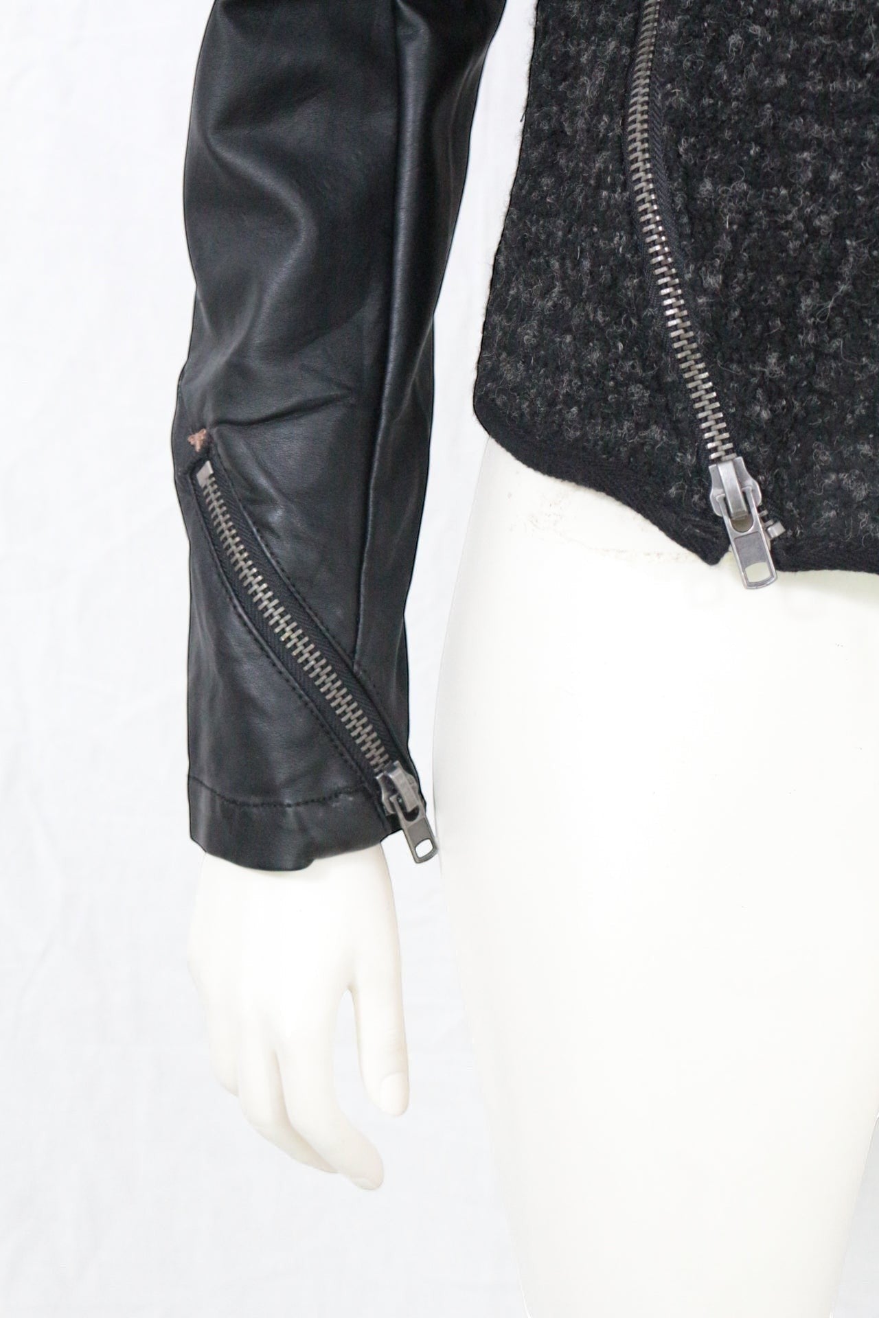 Veste biker Frippindealz noire en tweed texturé et simili cuir, zip asymétrique, clous et détails zippés.