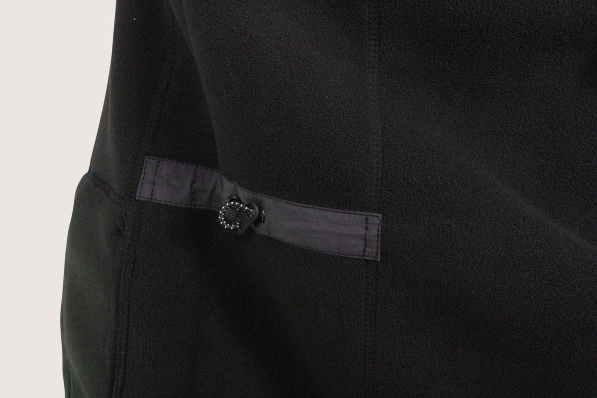 Détail de la veste blouson noire Rains chez Frippindealz avec patte de serrage et bouton pression