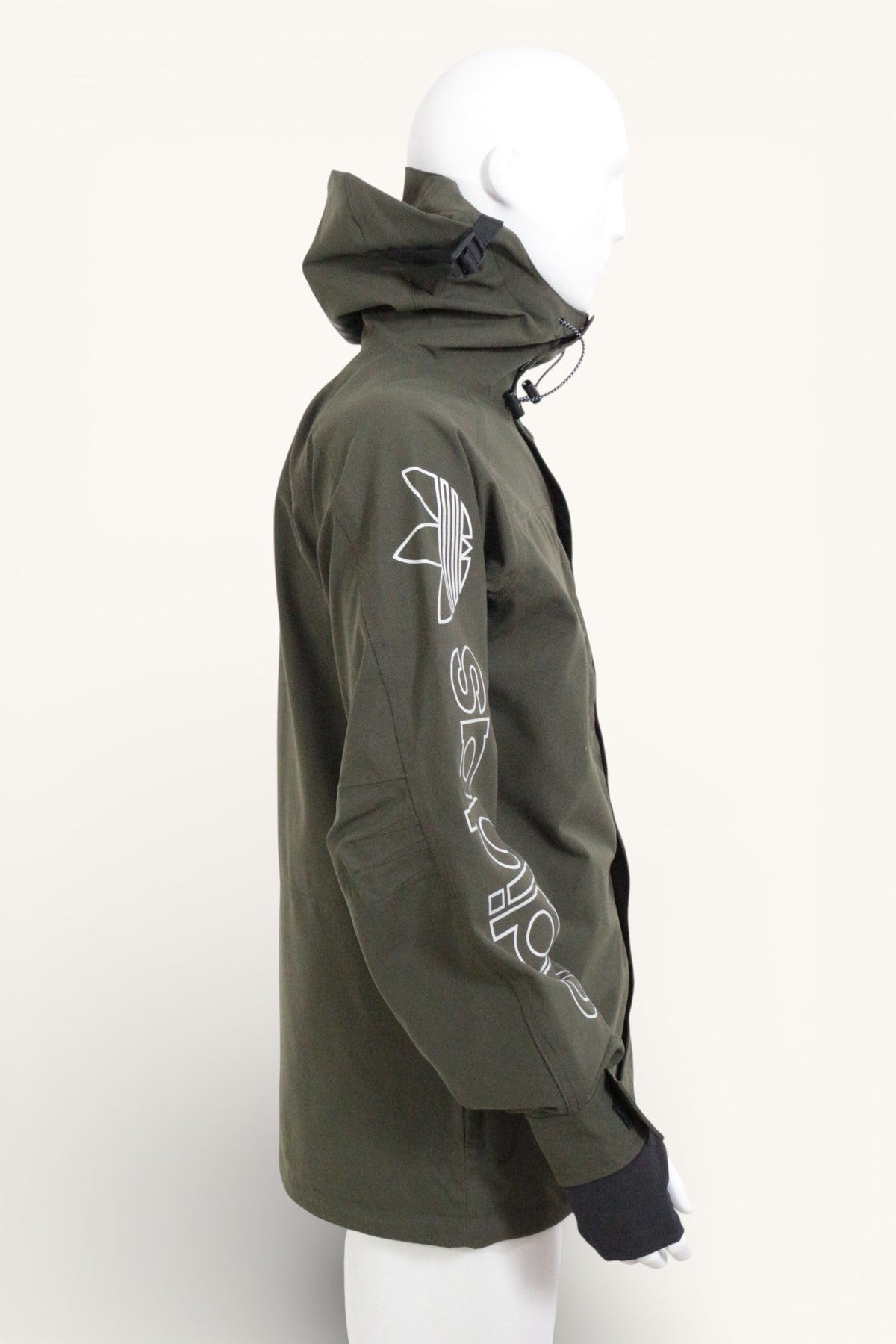 Veste de ski Frippindealz Adidas kaki avec logo blanc sur la manche et capuche intégrée portée sur un mannequin