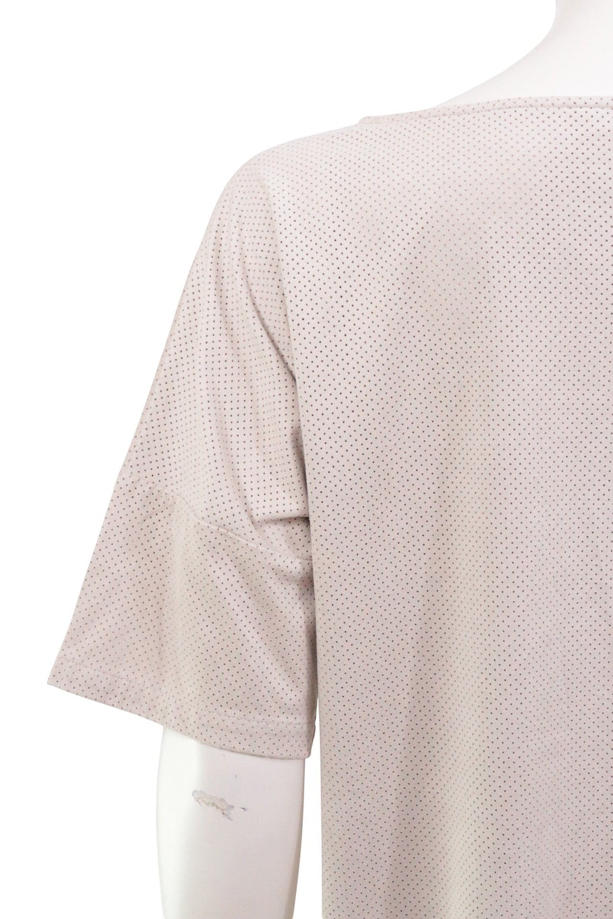 Gros plan sur la manche d'une robe courte Frippindealz Zara beige en polyester perforé effet daim