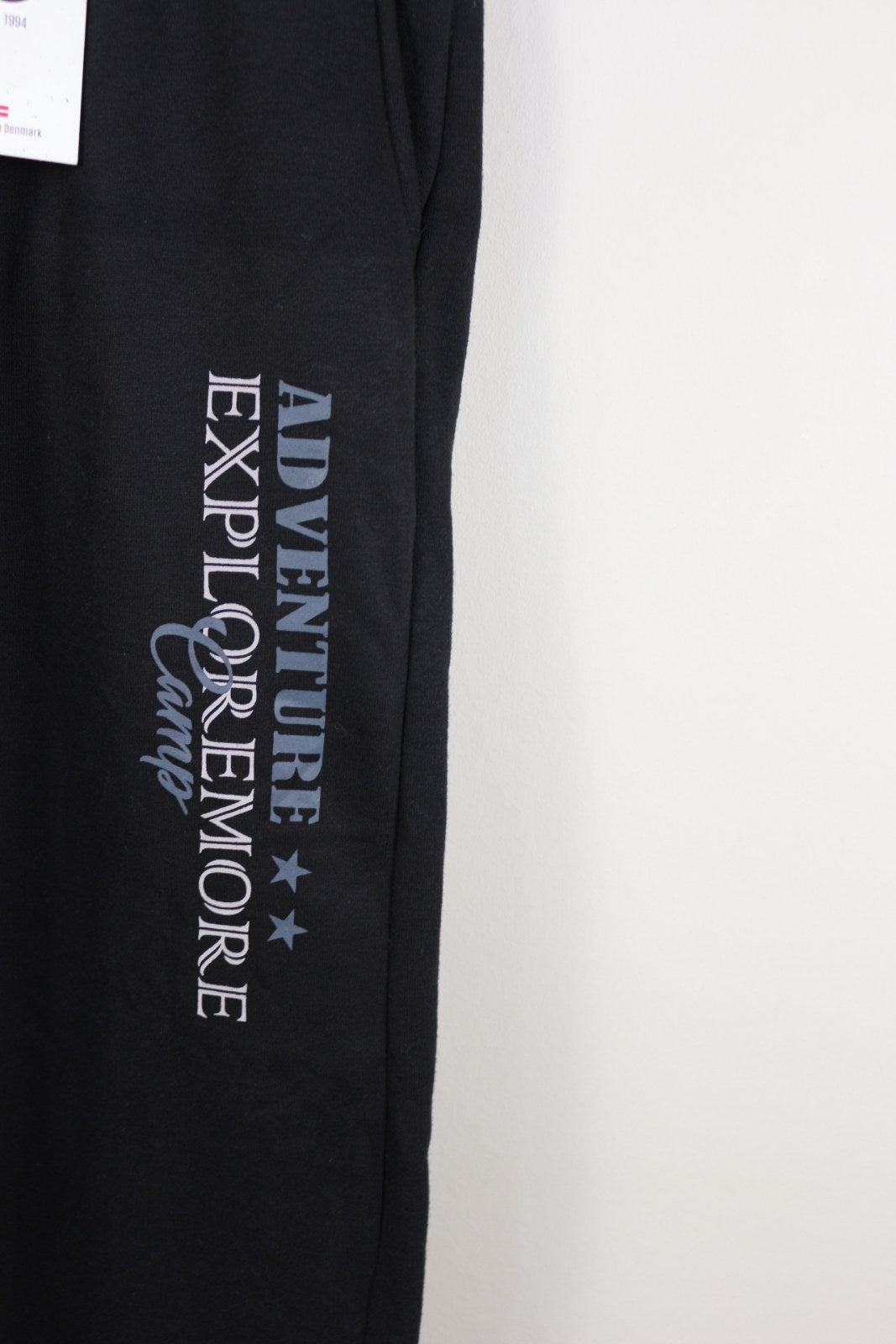 Détail de l'imprimé Adventure Explore More Camp sur la jambe du jogging Marcus noir – Frippin'Dealz